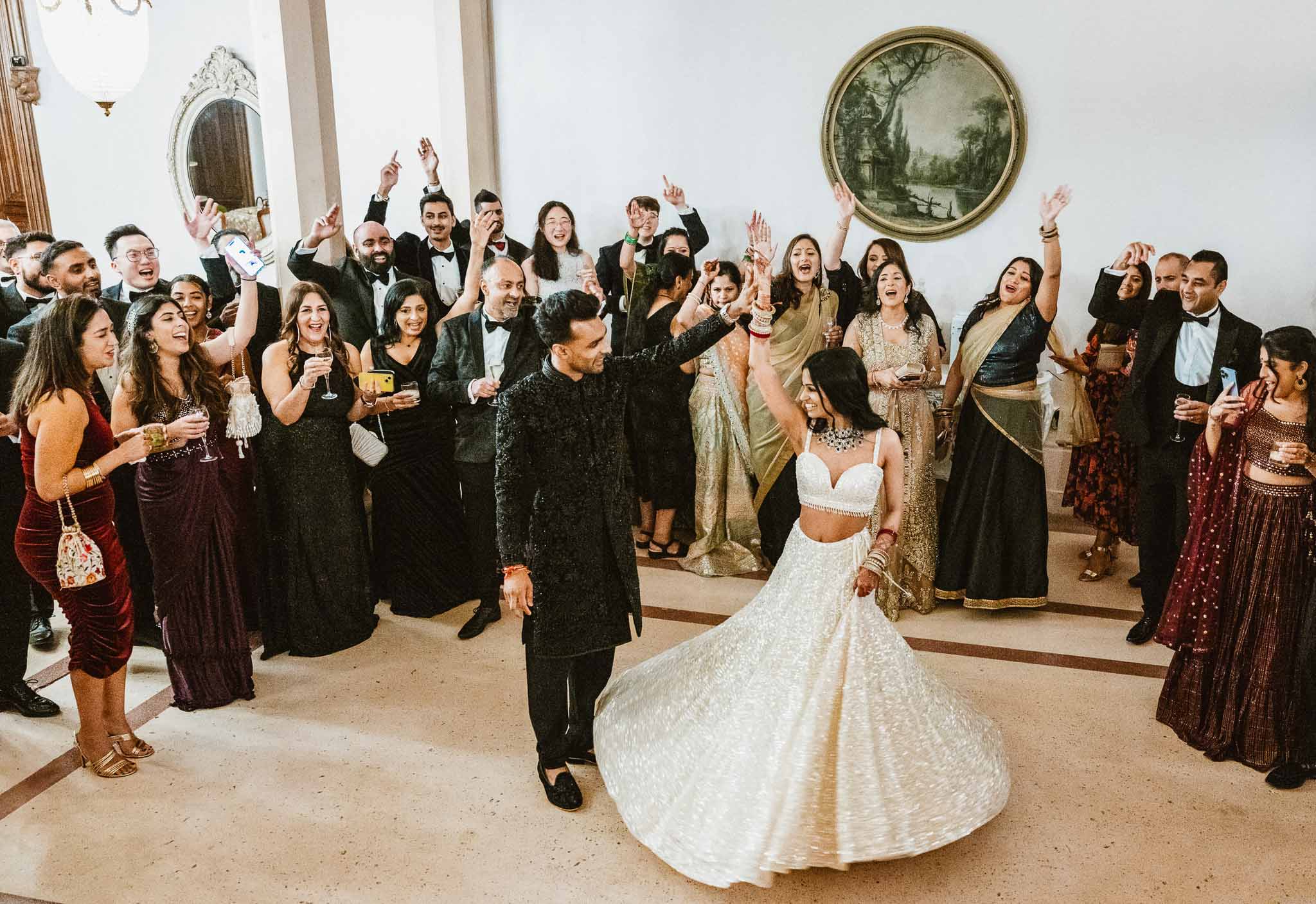 First dance with guests celebrating at elegant indoor wedding reception venue