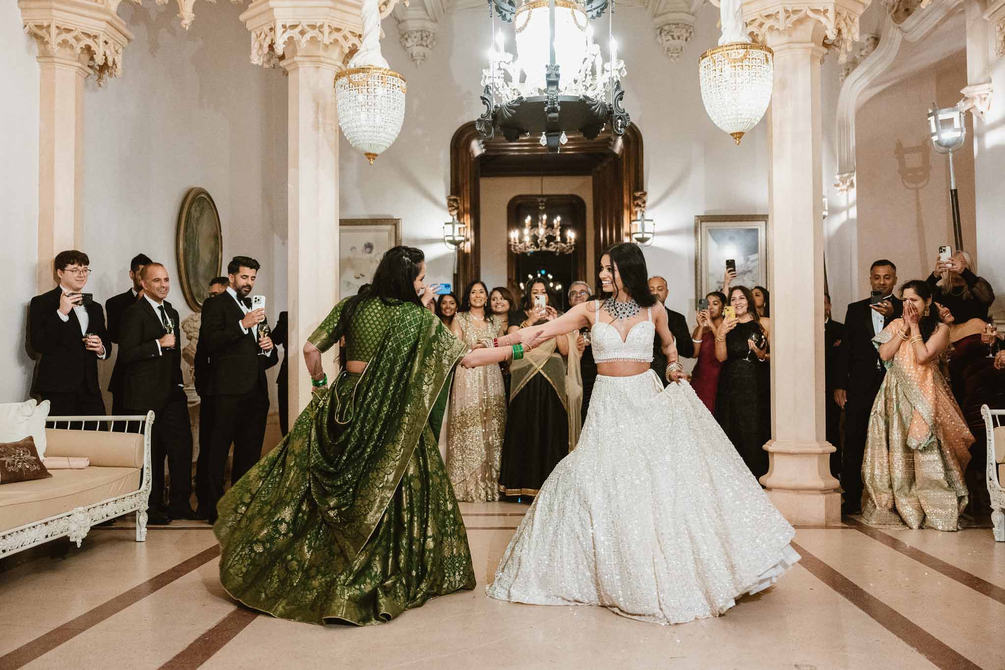 Bride dancing with guest in ornate neoclassical ballroom during wedding reception