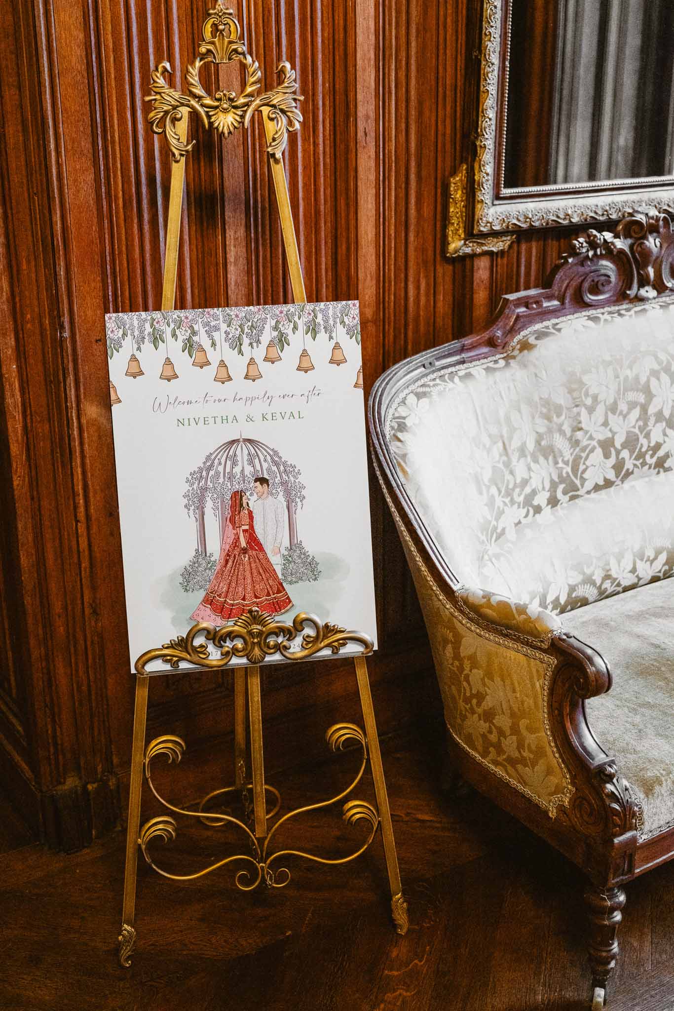 Custom welcome sign on gold easel with Indian wedding styling in formal interior venue
