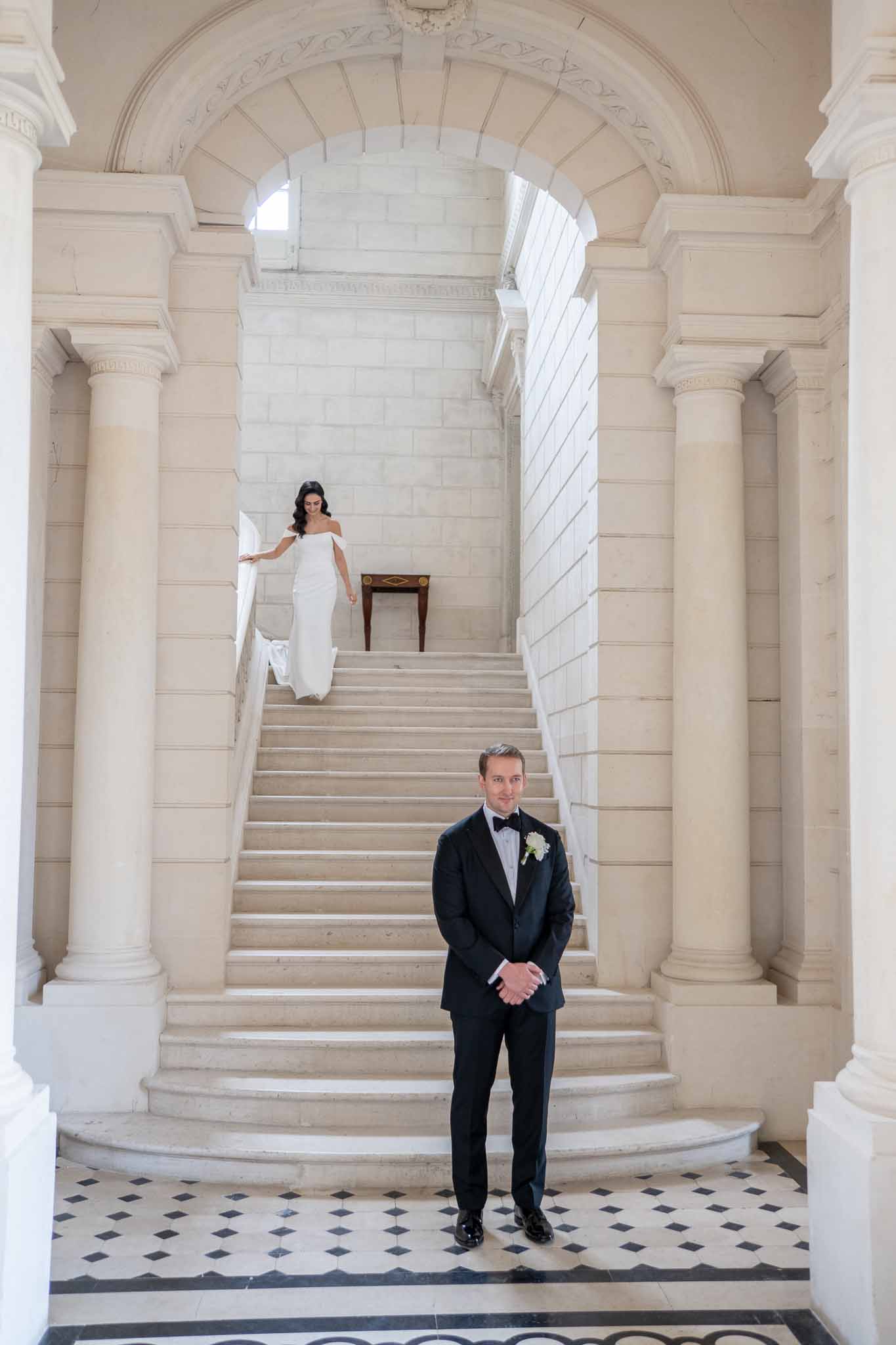 Bride and groom portrait on neoclassical staircase with columns and ornate architecture
