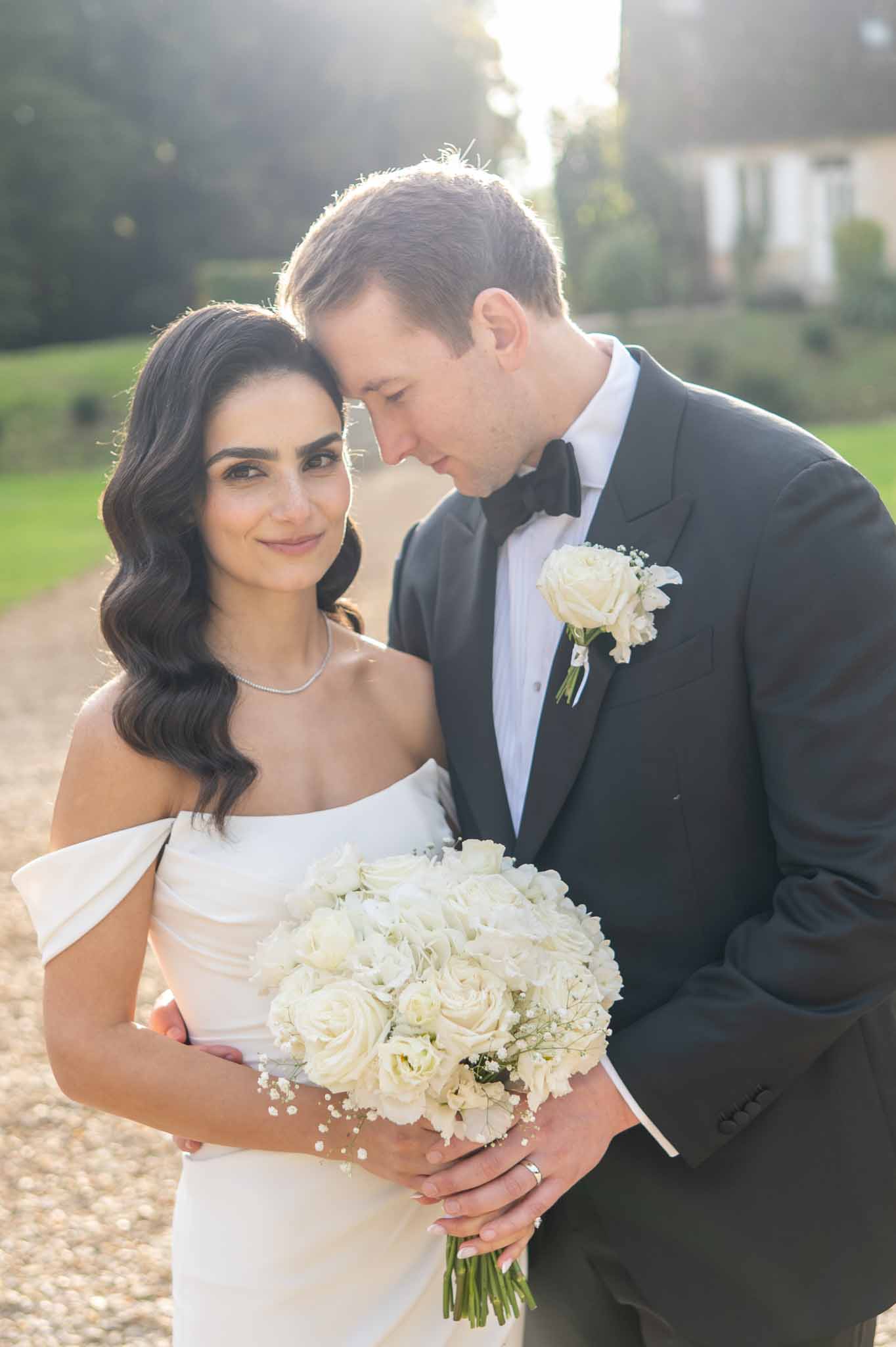 Bride and groom portrait during golden hour at elegant estate with manicured gardens