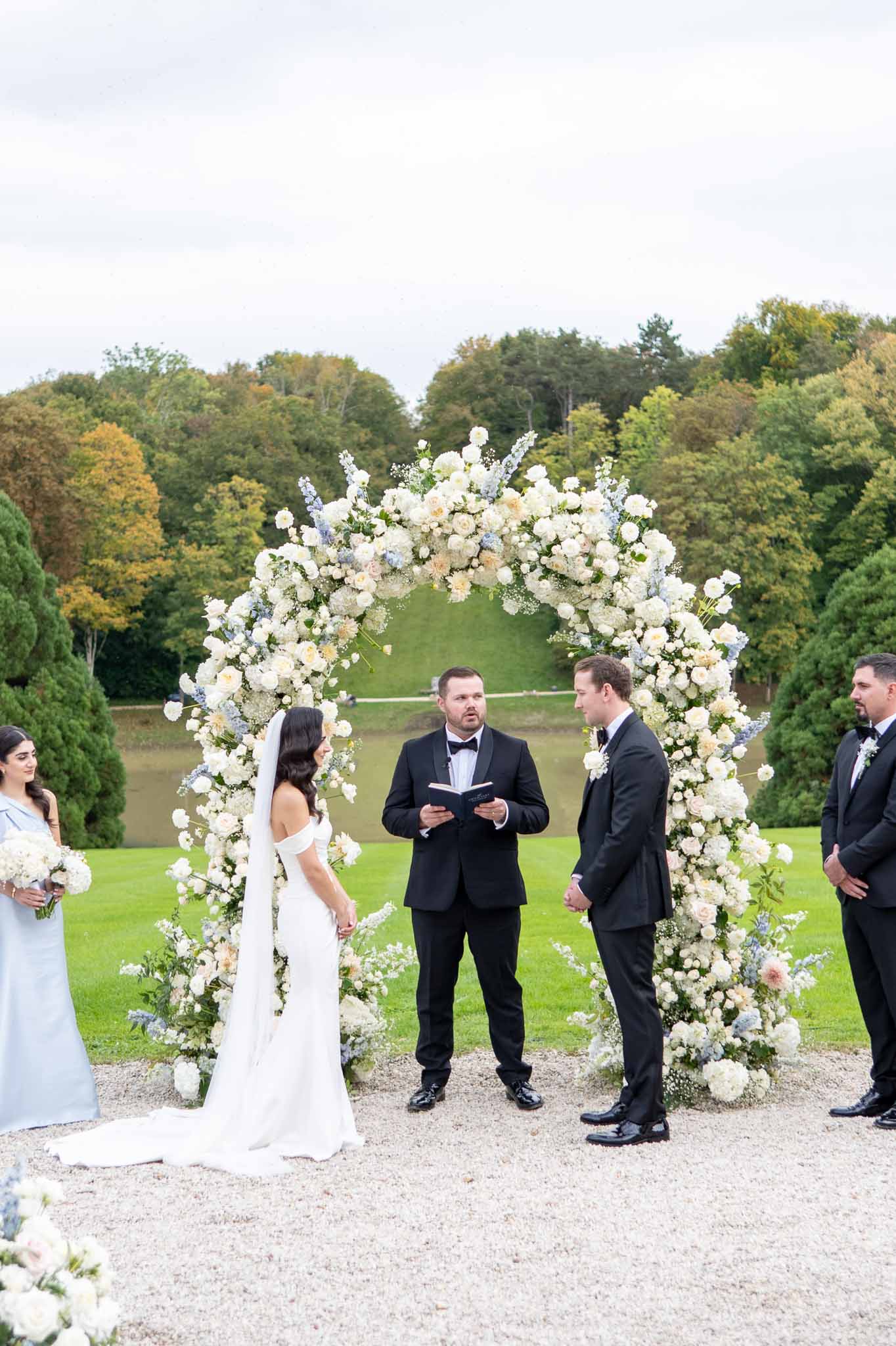 Outdoor wedding ceremony with floral arch in garden setting