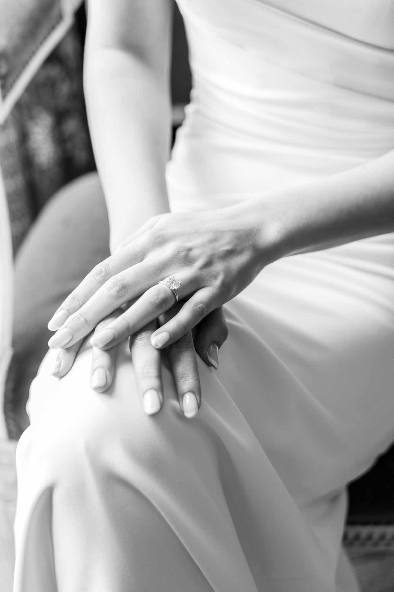 Bride and groom's hands showing wedding rings in black and white portrait