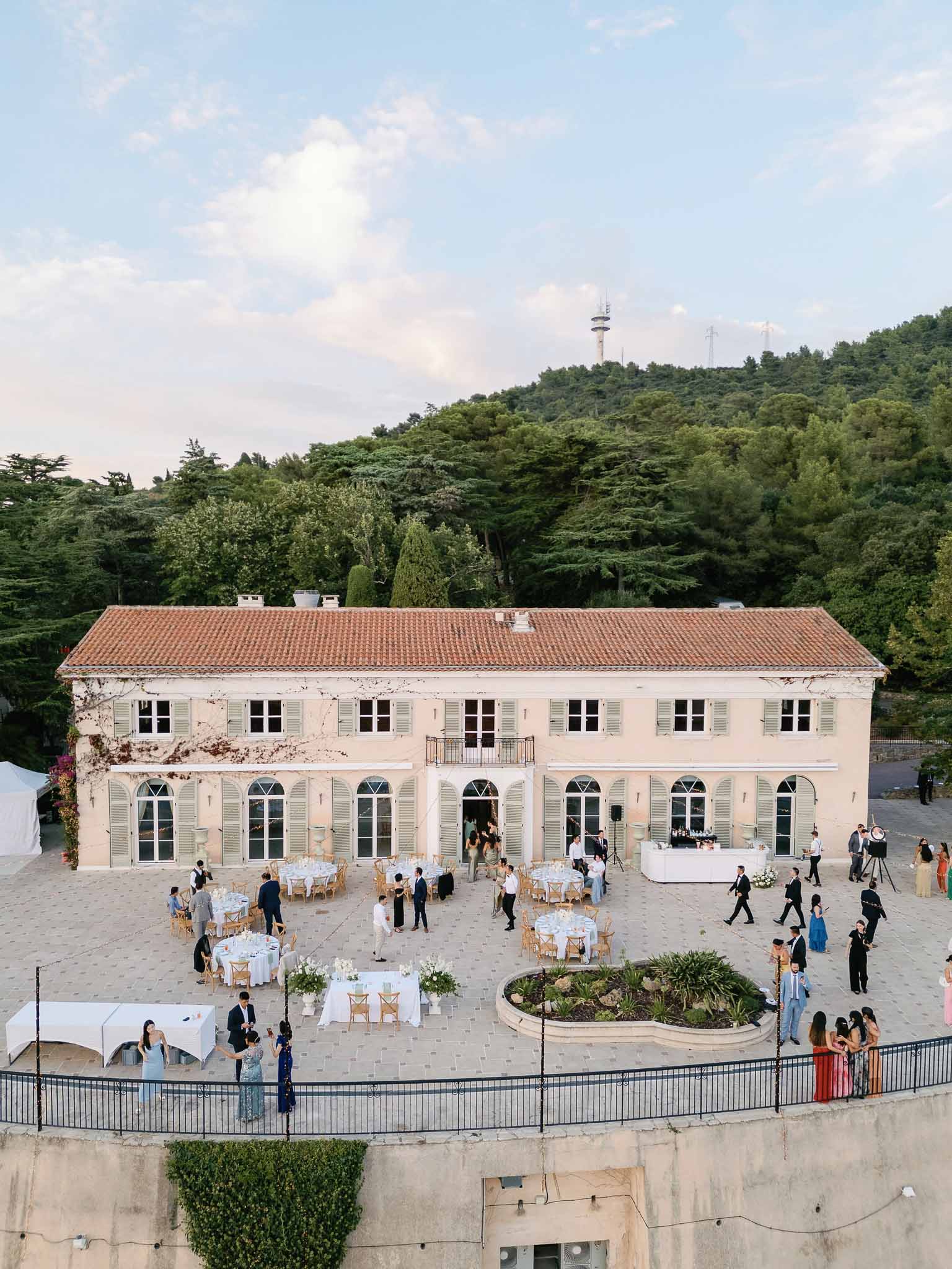 Aerial view of wedding reception in neoclassical venue courtyard with guests at round tables