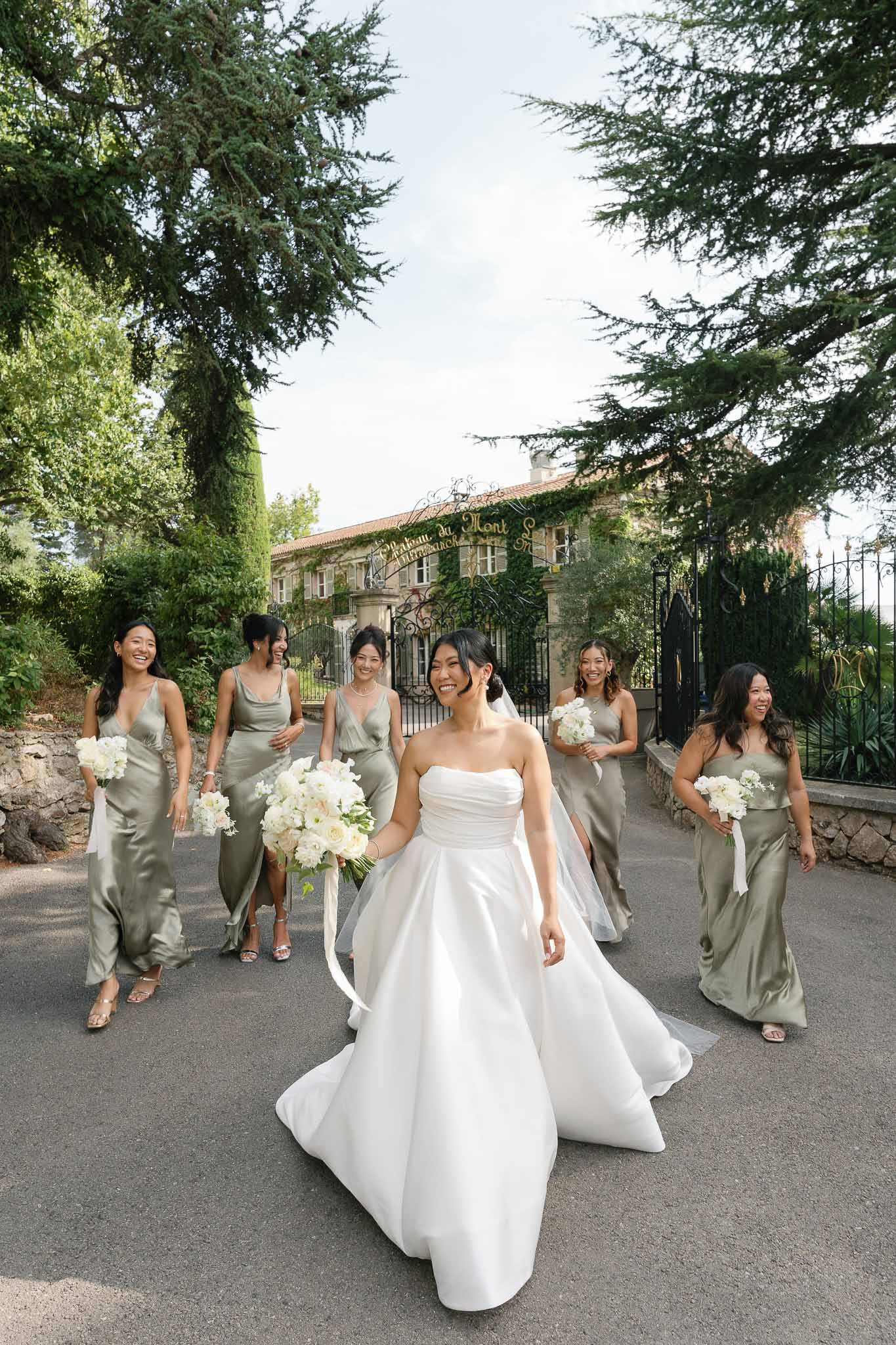 Bride and bridesmaids walking along stone pathway at Mediterranean villa