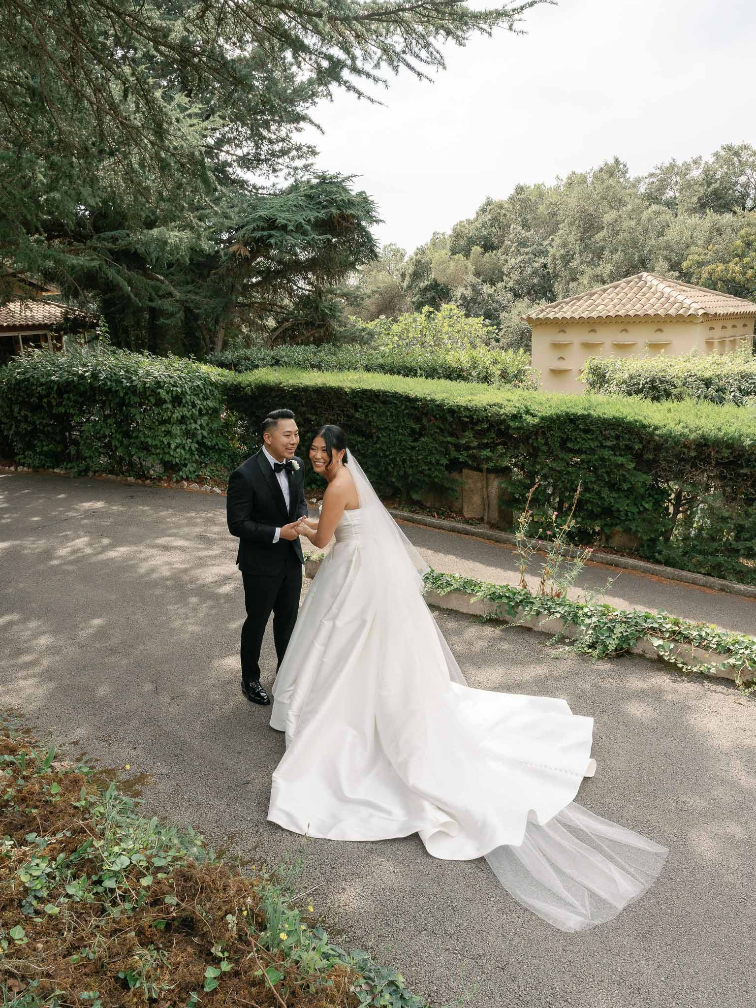 Bride and groom portrait session in European-style stone courtyard with manicured hedges