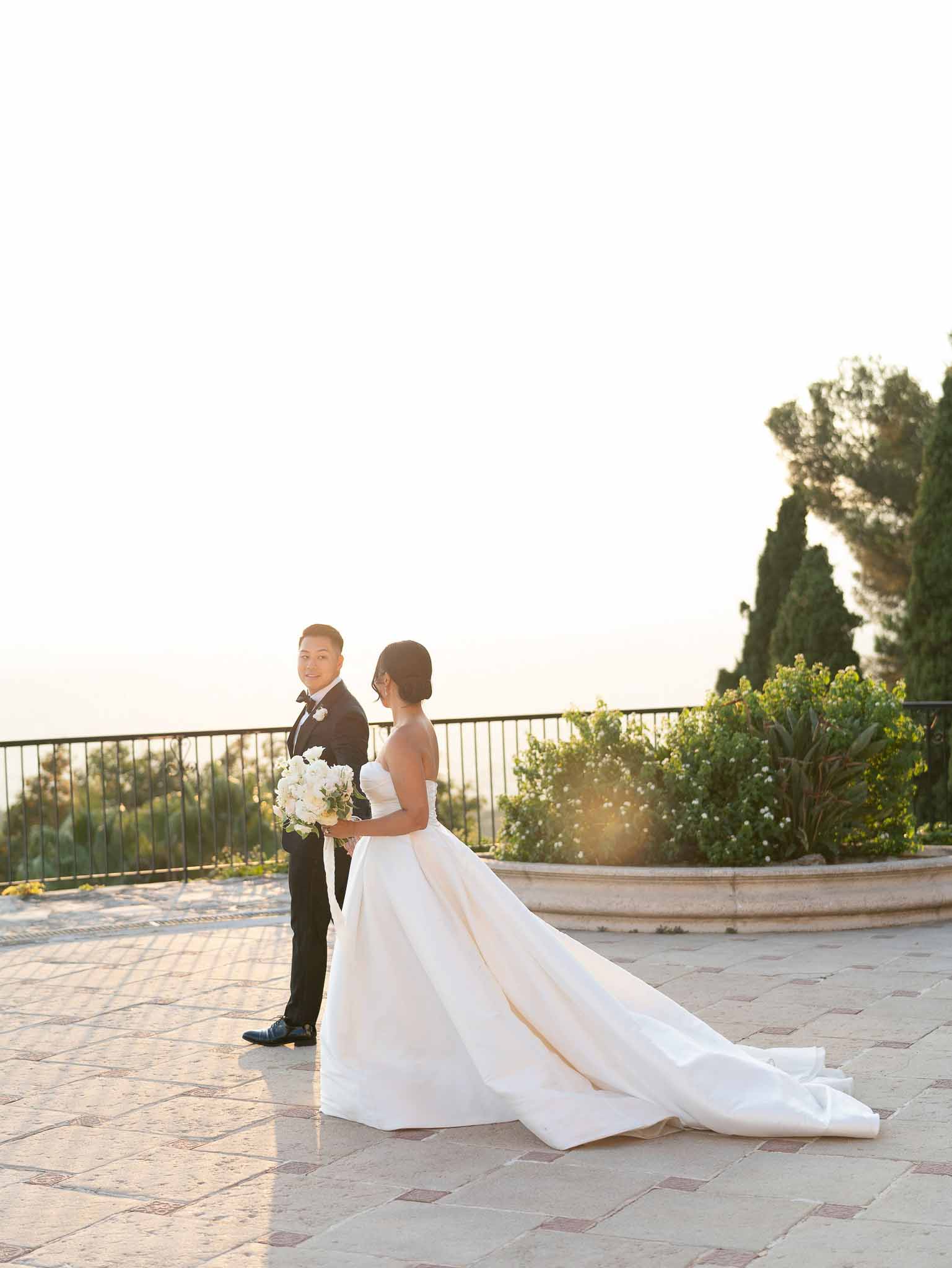 Bride and groom portrait on stone terrace overlooking landscape at elegant venue