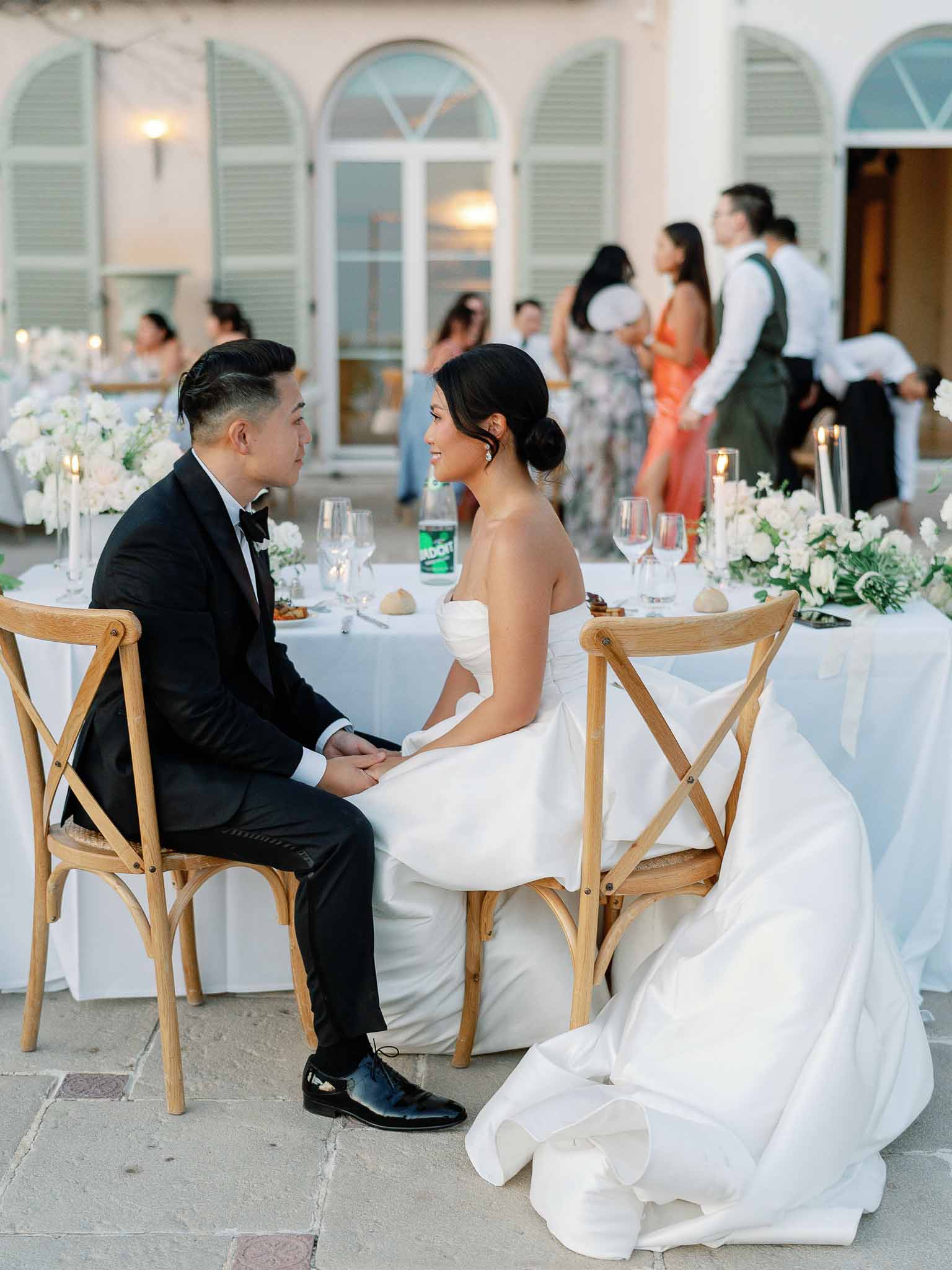 Bride and groom sharing intimate moment at decorated reception table in Mediterranean courtyard