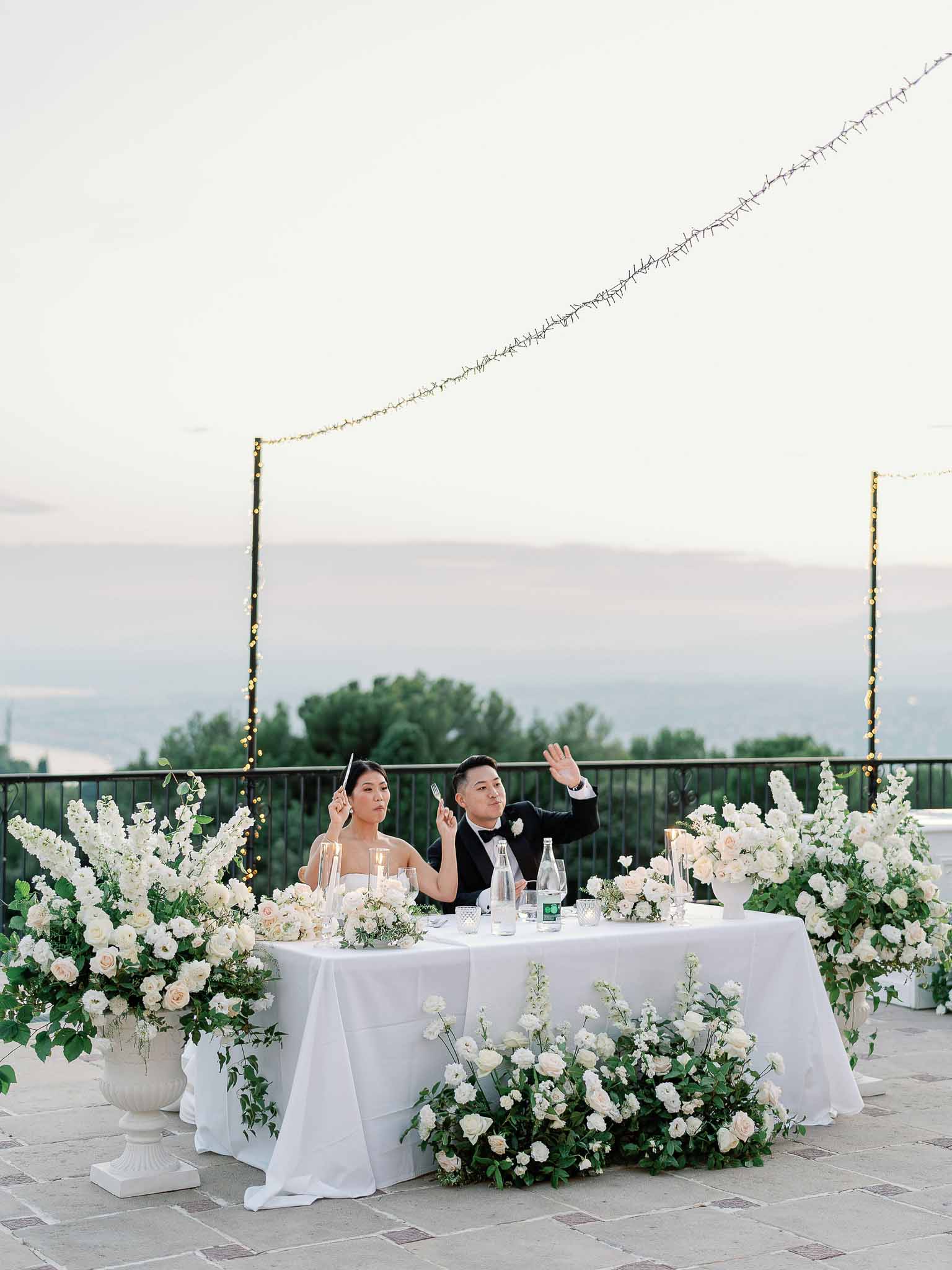 Bride and groom at sweetheart table during speeches at outdoor mountain terrace reception