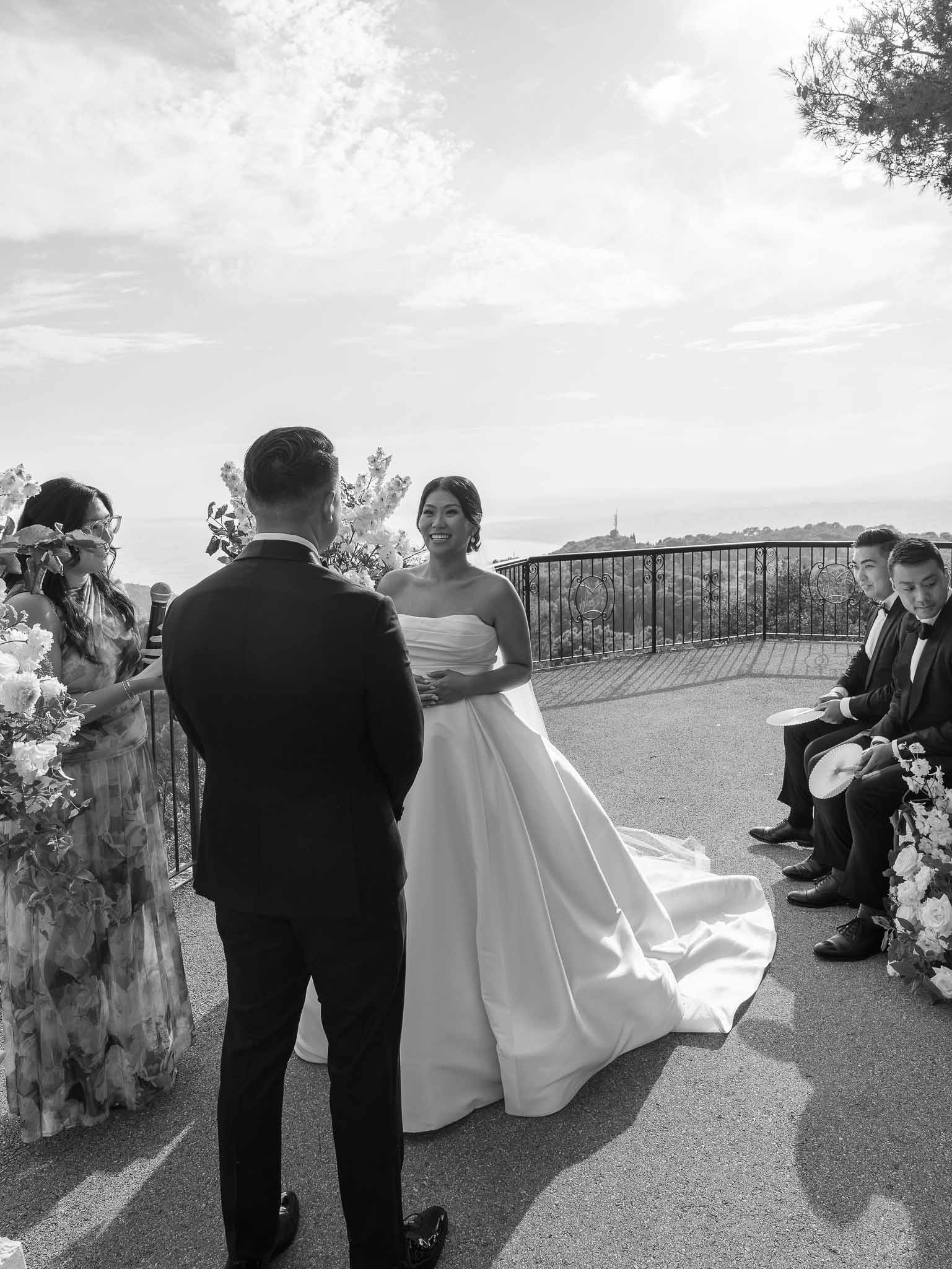 Wedding ceremony on outdoor terrace with bride and groom exchanging vows overlooking scenic landscape