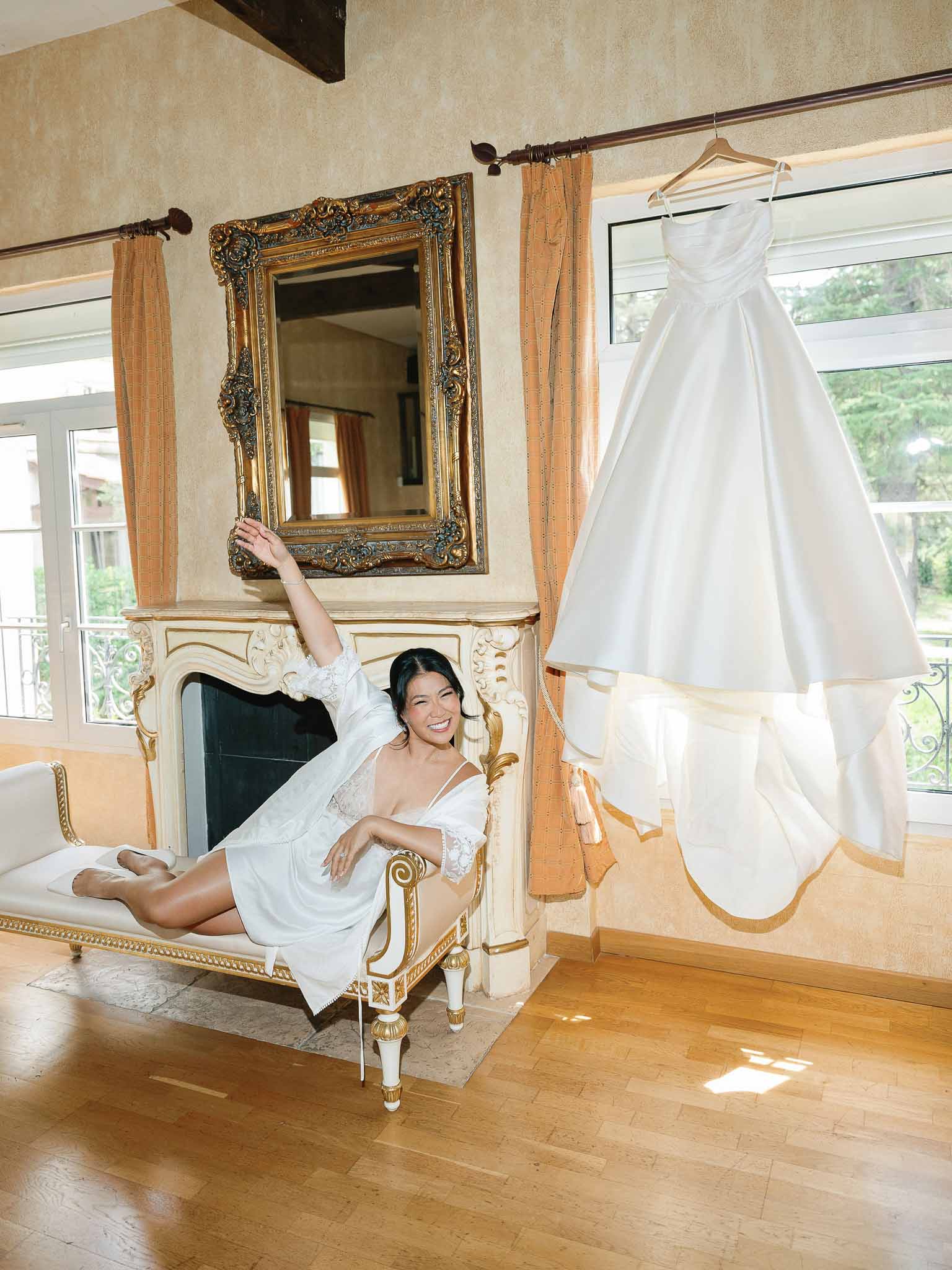 Bride in silk robe during getting ready portrait in ornate French-inspired dressing room