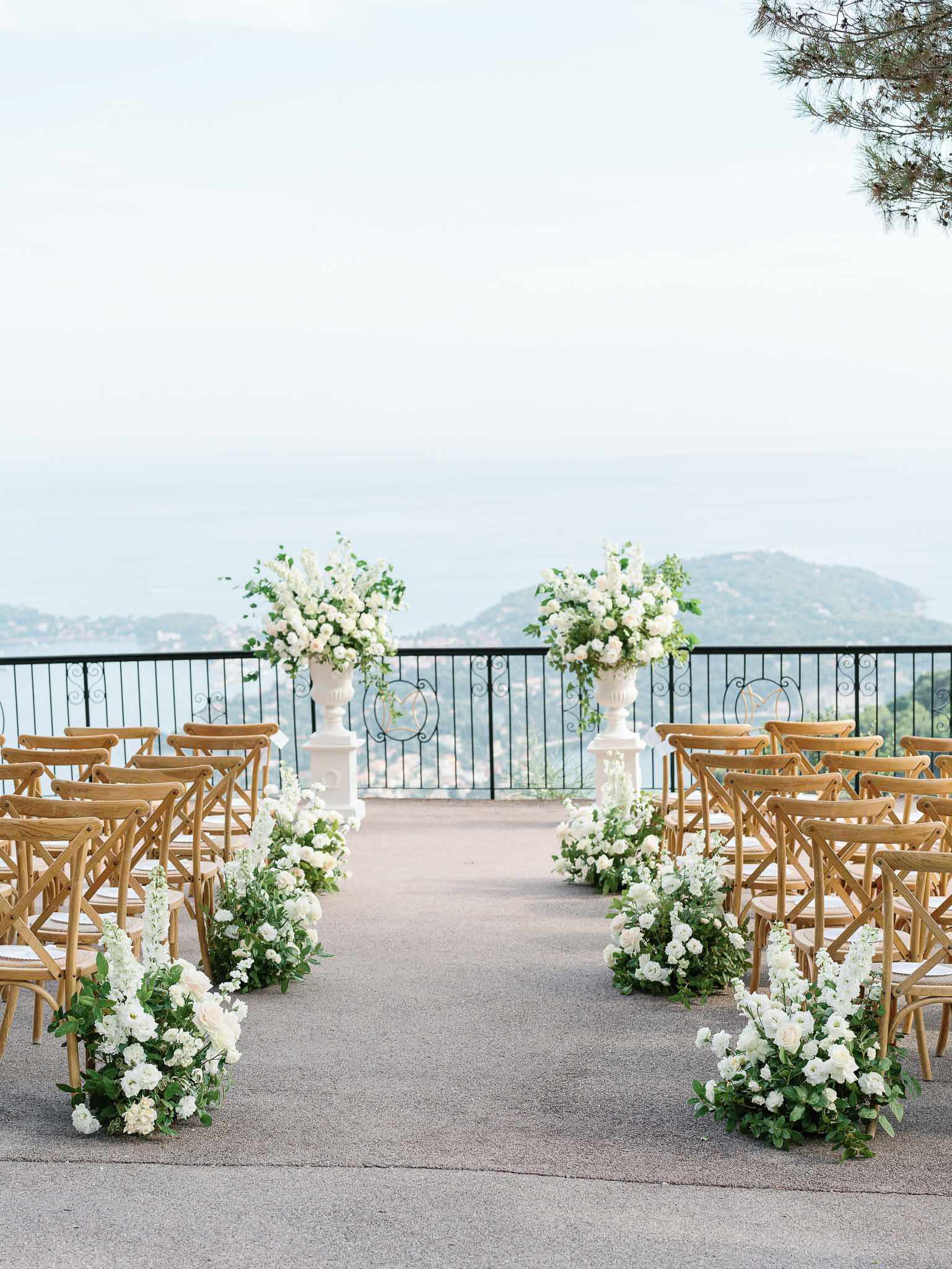 Outdoor ceremony setup with crossback chairs on elevated terrace overlooking rolling hills