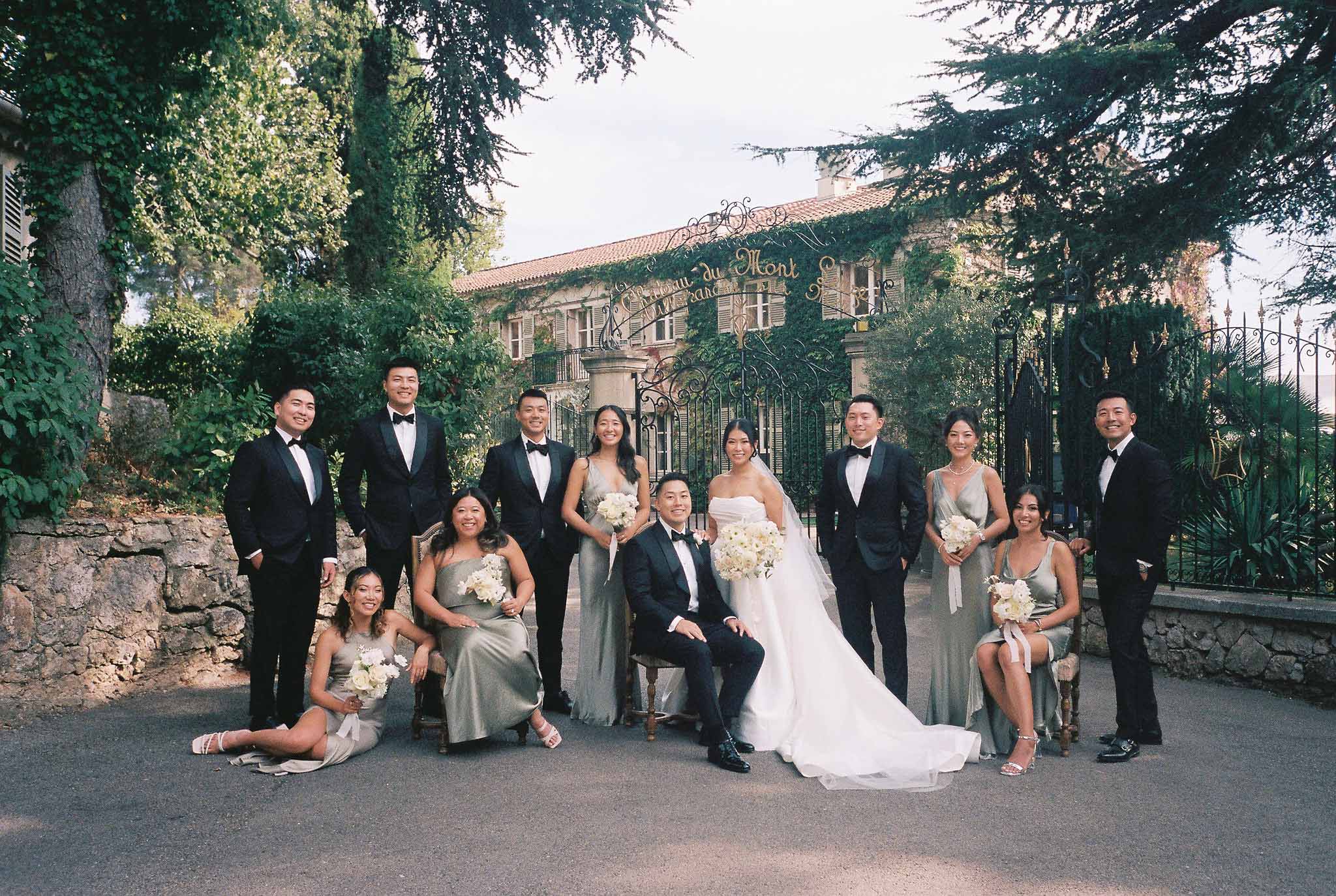 Formal bridal party portrait with bride, groom and attendants at historic stone villa with ivy-covered walls