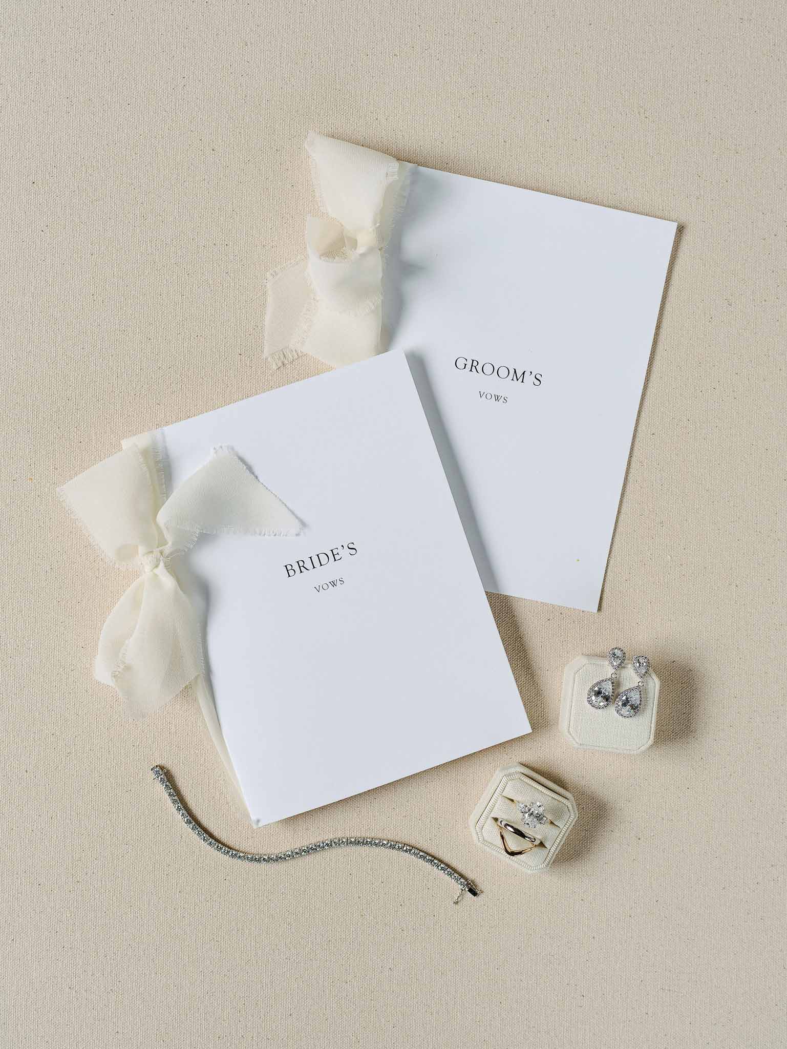 Wedding vow books and rings arranged on neutral linen background
