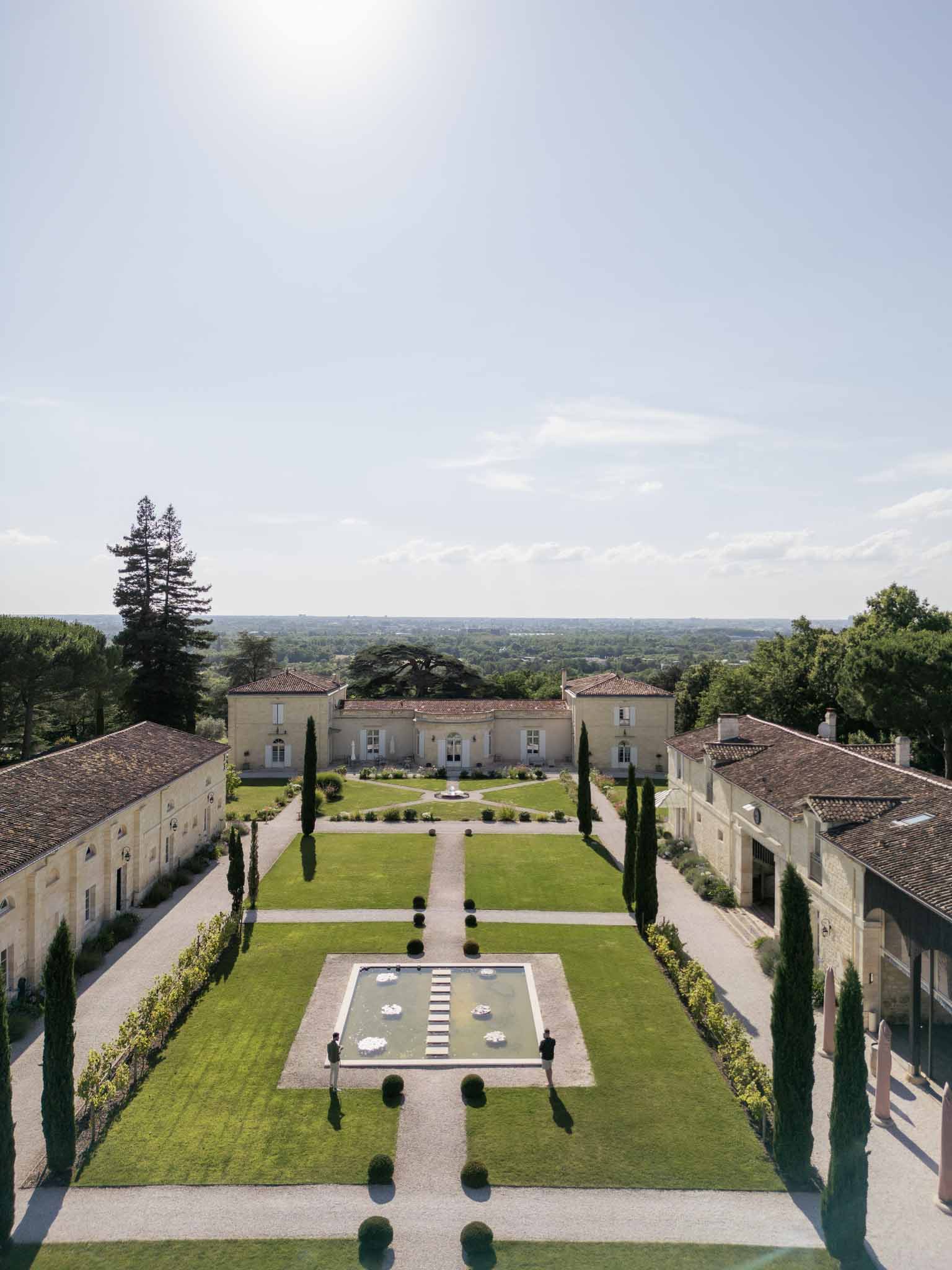 Aerial view of French château wedding venue with formal gardens and geometric landscaping