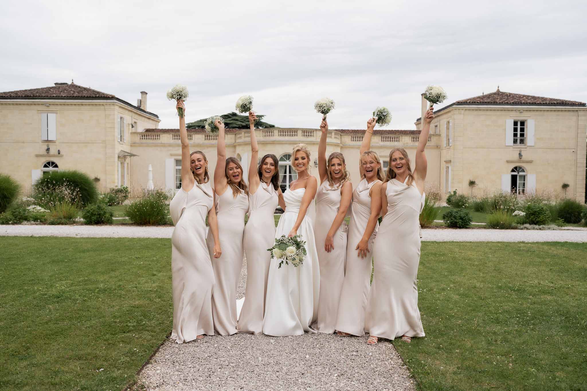 Bride and bridesmaids group portrait with white bouquets at French château