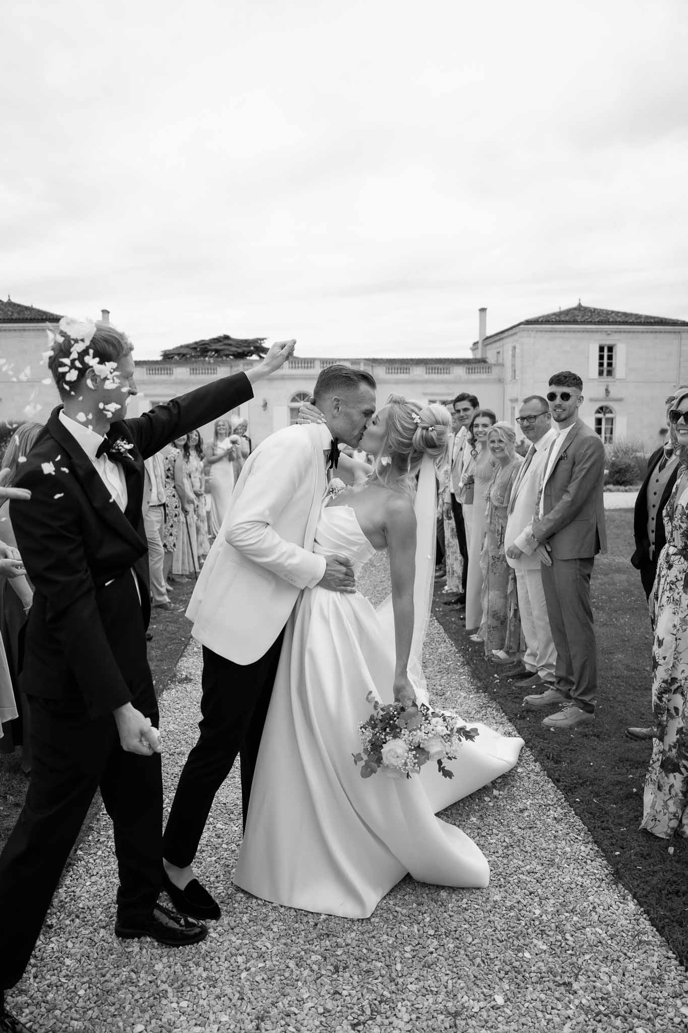 Couple's recessional exit with guests lining pathway at neoclassical courtyard venue