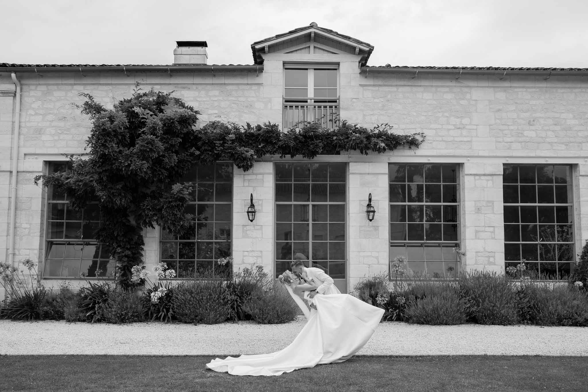 Bride in flowing wedding dress twirling on lawn at modern farmhouse venue