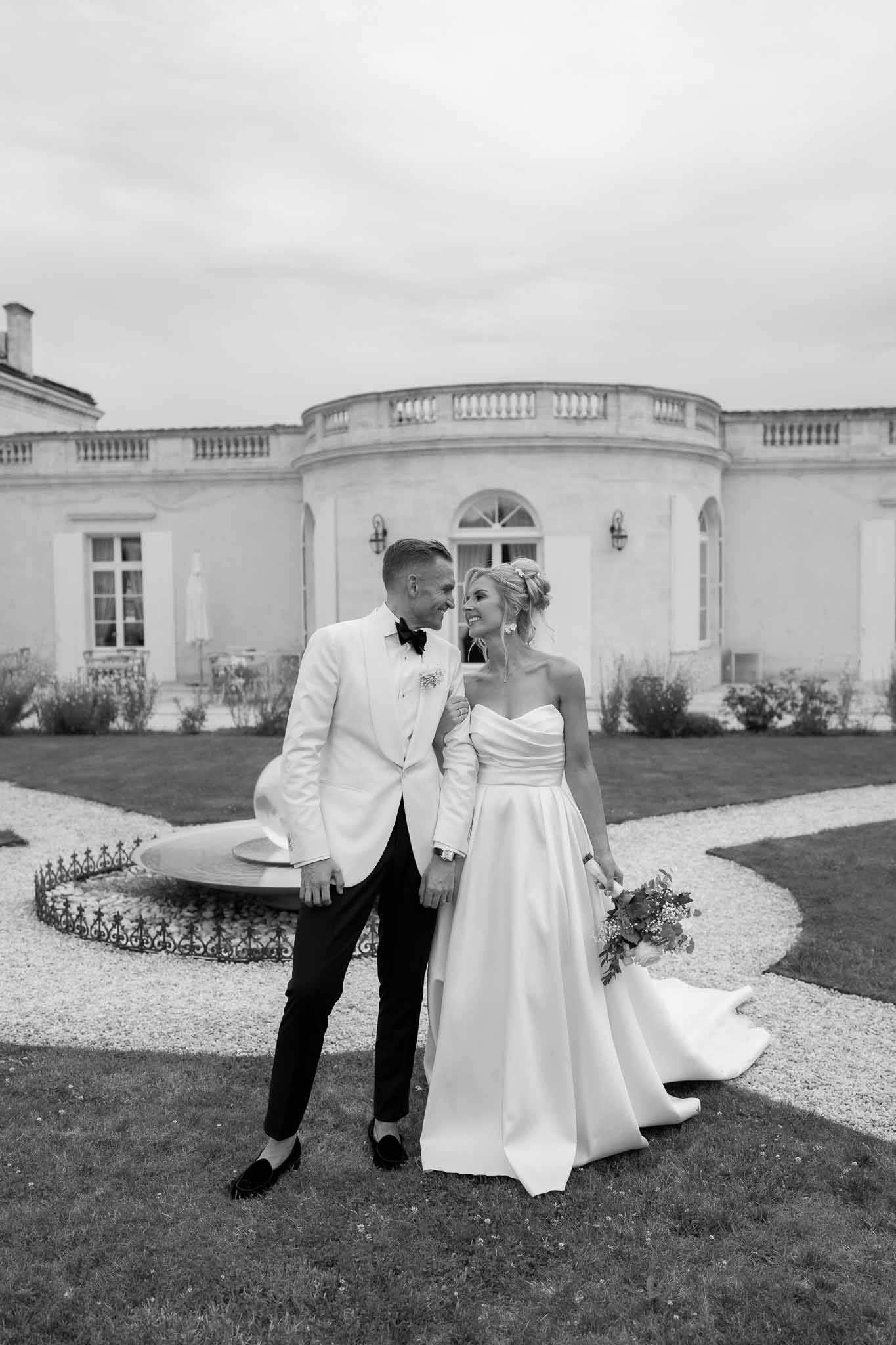 Bride and groom formal portrait on mansion grounds with neoclassical colonnade architecture