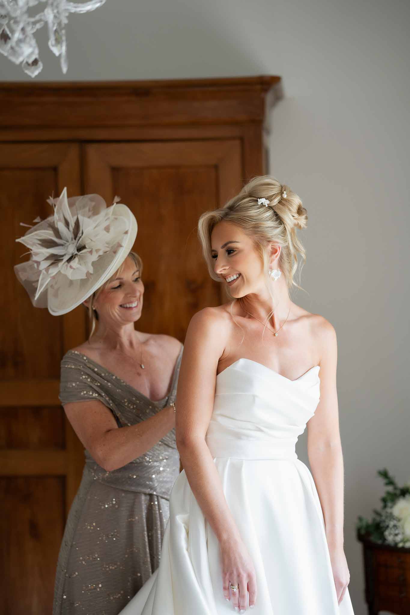 Bride in ivory gown with guest in elegant interior setting