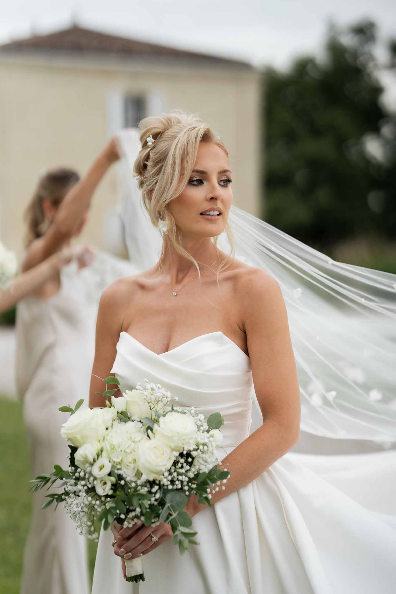 Bride in ivory strapless dress with white rose bouquet at countryside estate wedding