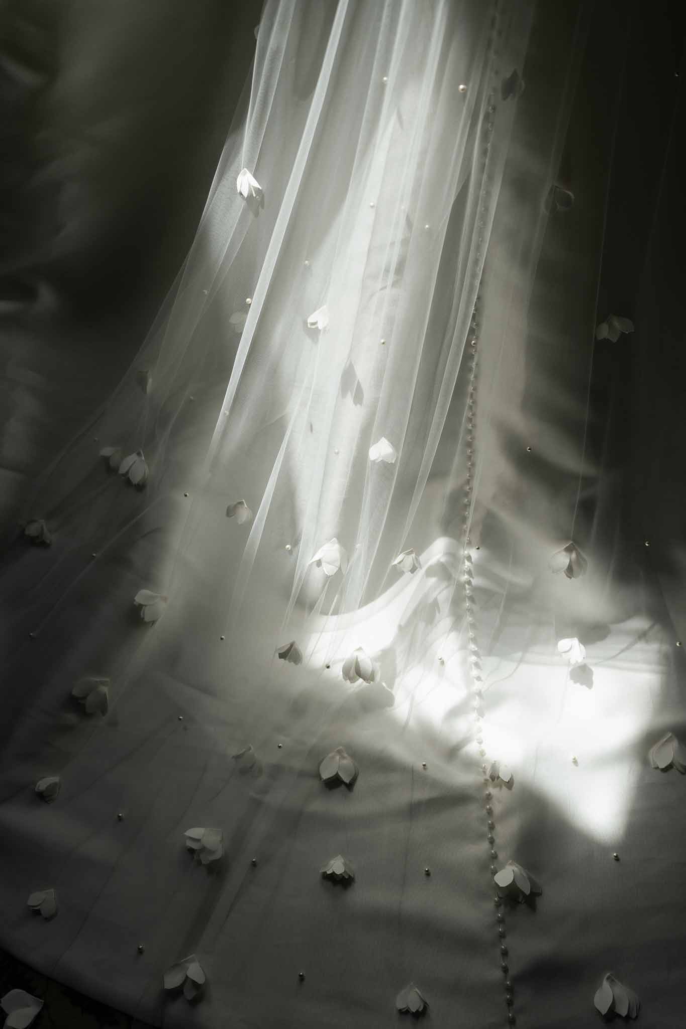 Close-up detail of embellished bridal veil with floral appliqués and beaded trim in black and white