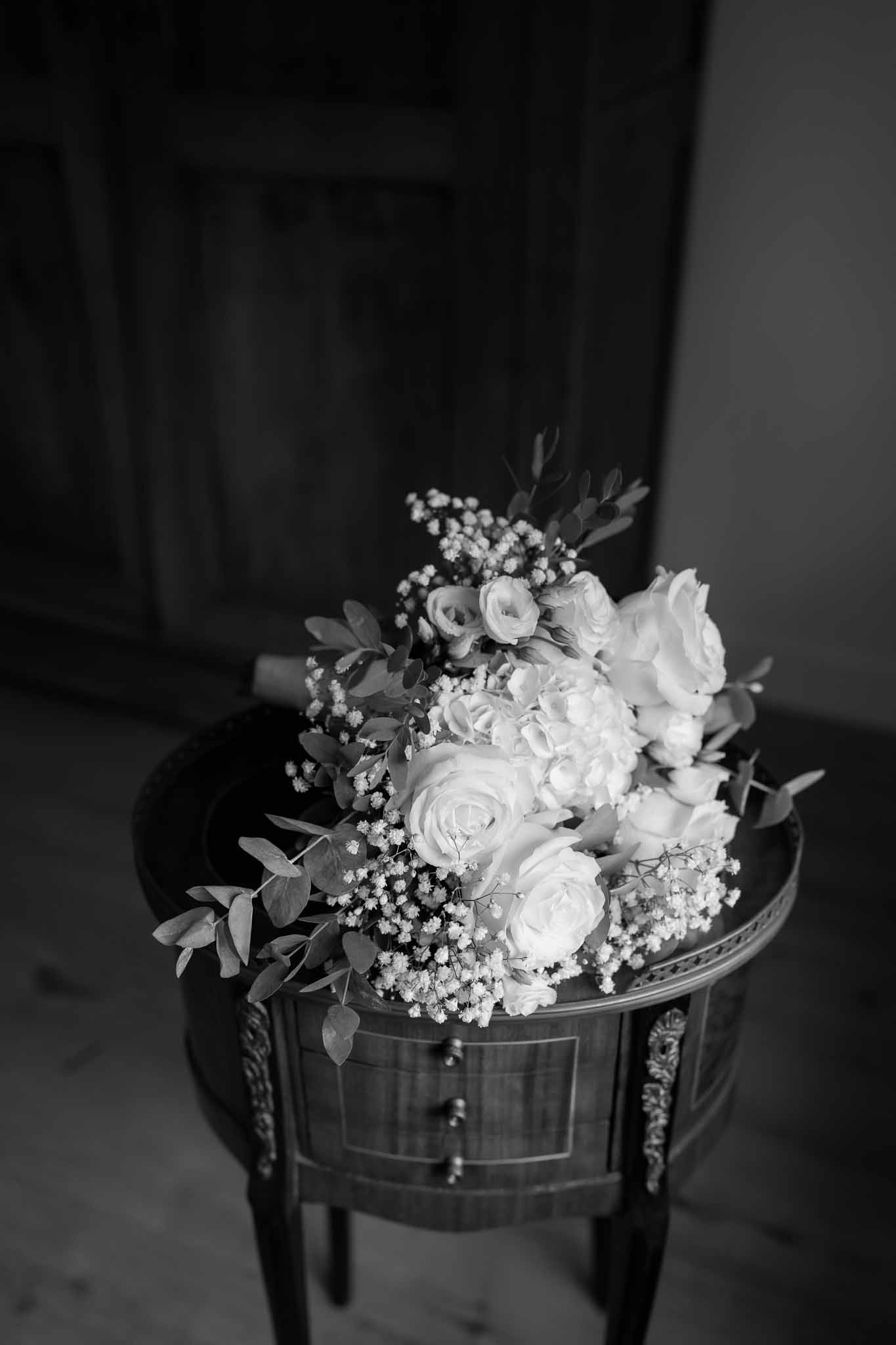Black and white bridal bouquet with garden roses on ornate wooden table