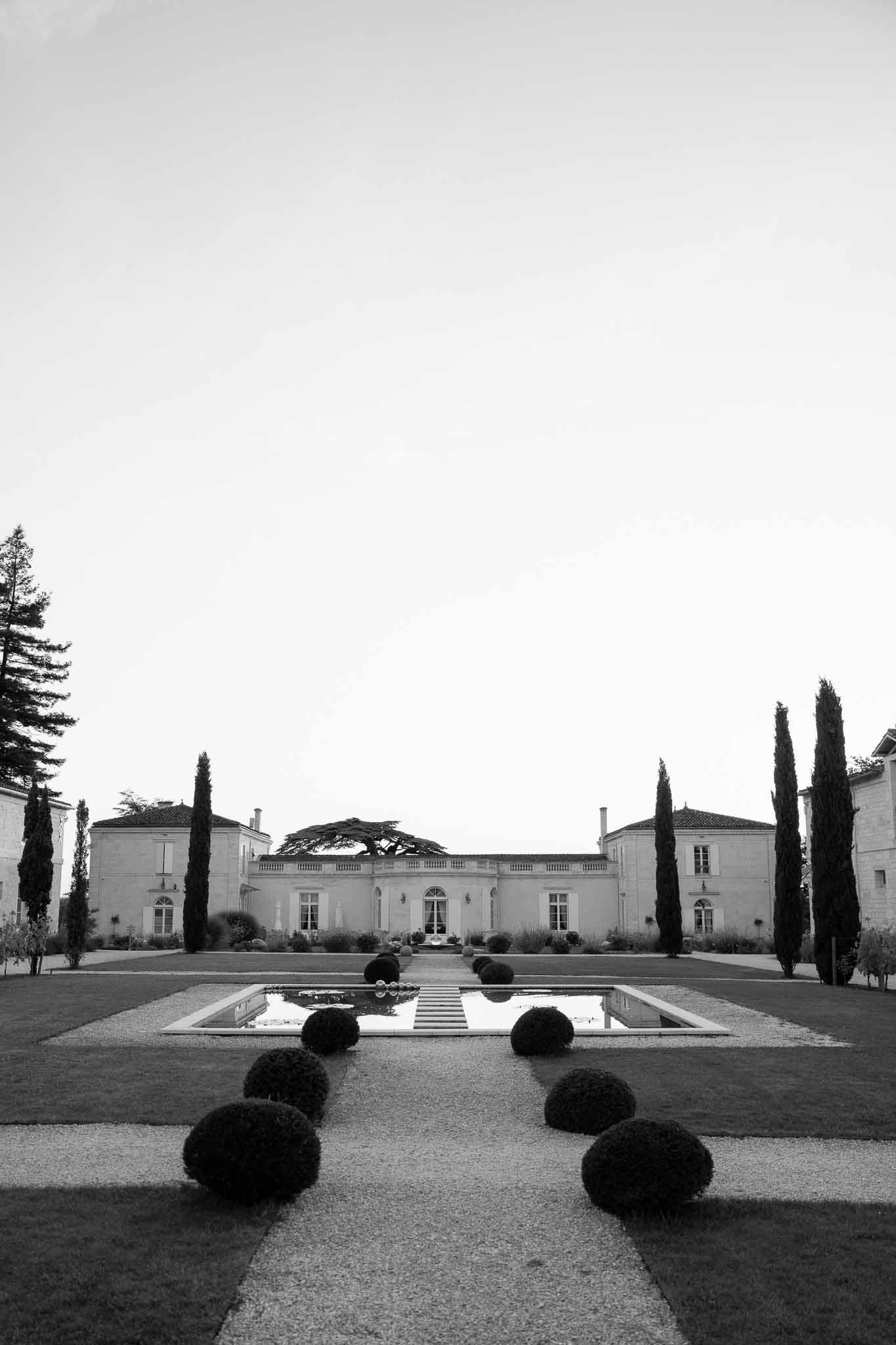 Classical estate mansion with reflecting pool and formal gardens in black and white