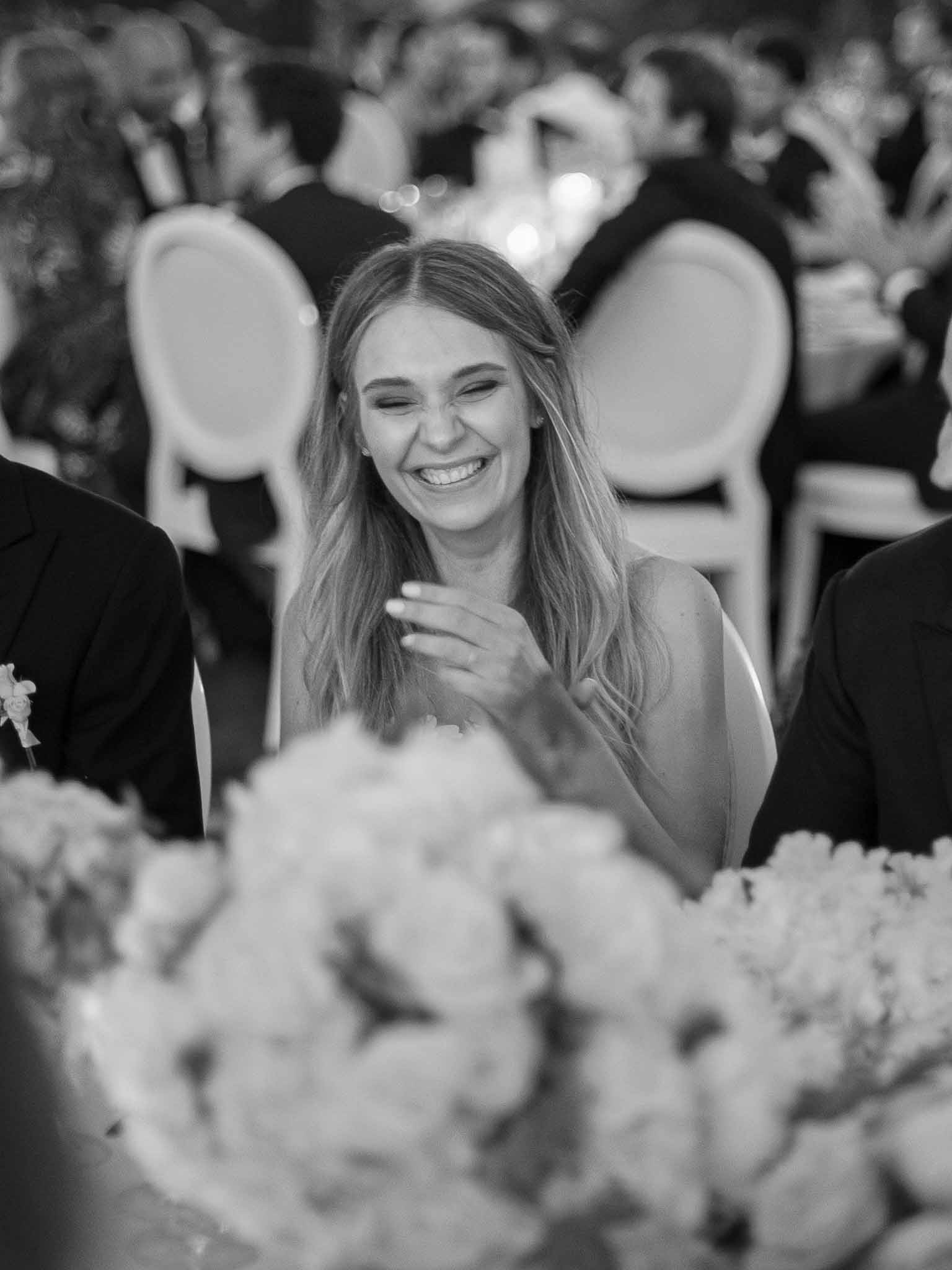 Wedding guest smiling during reception dinner at elegant venue