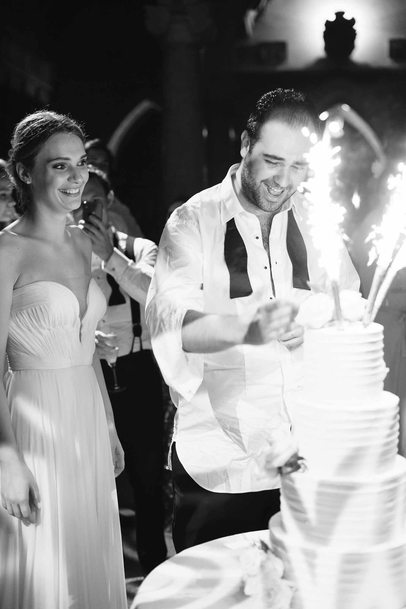 Bride and groom cutting wedding cake during evening reception
