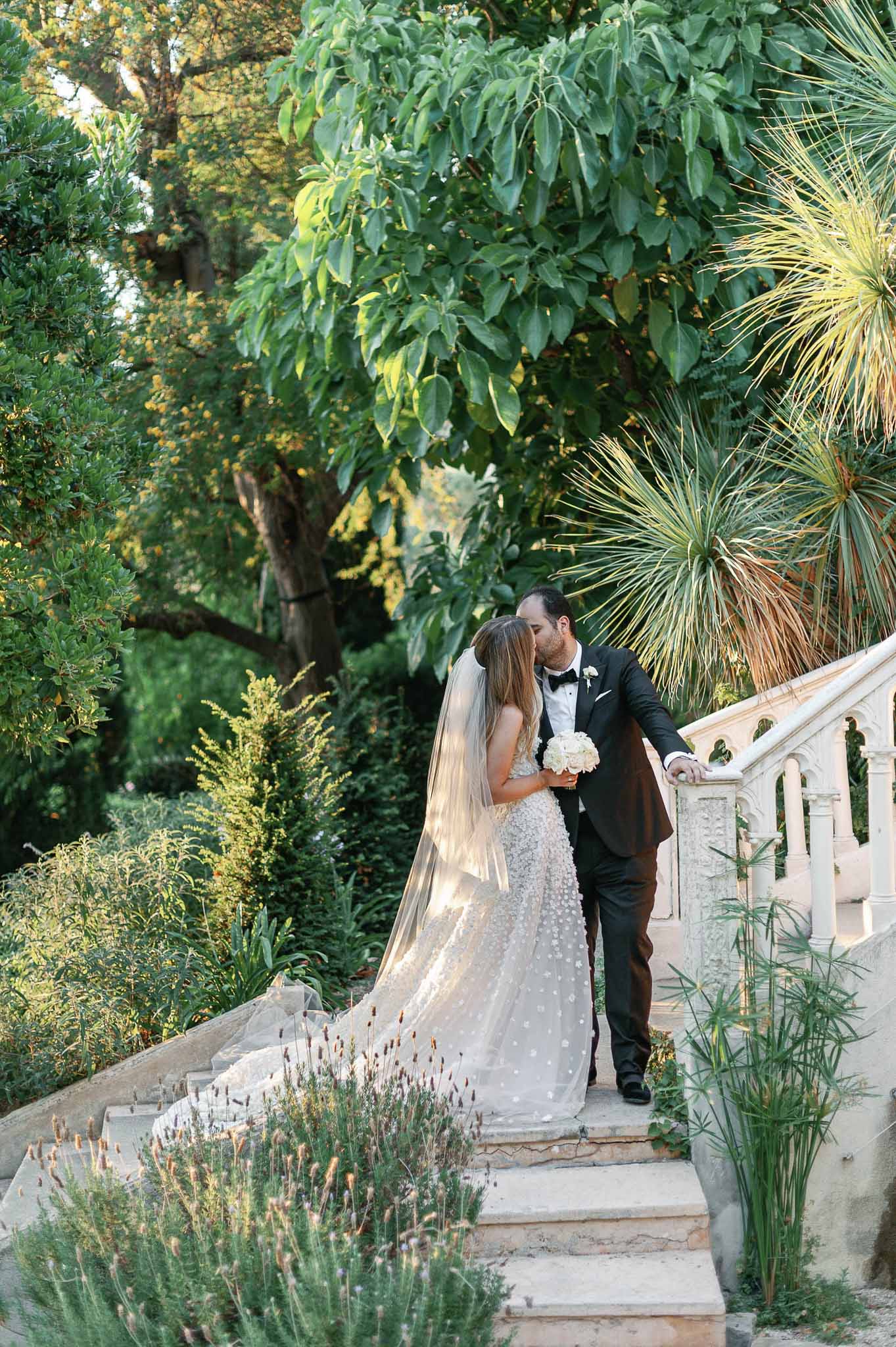Wedding couple portrait on stone pathway in formal garden with lavender and mature trees