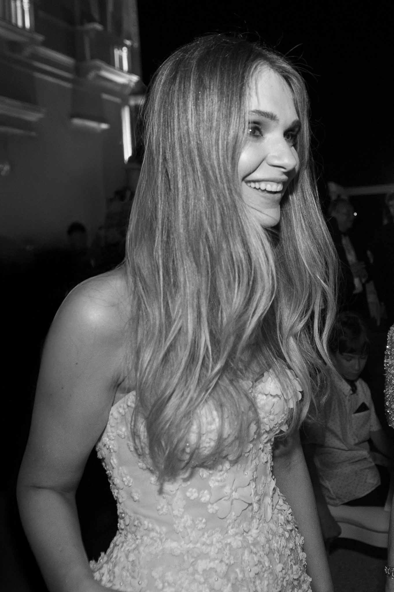 Black and white bridal portrait showing bride in profile with textured floral appliqué dress at indoor reception