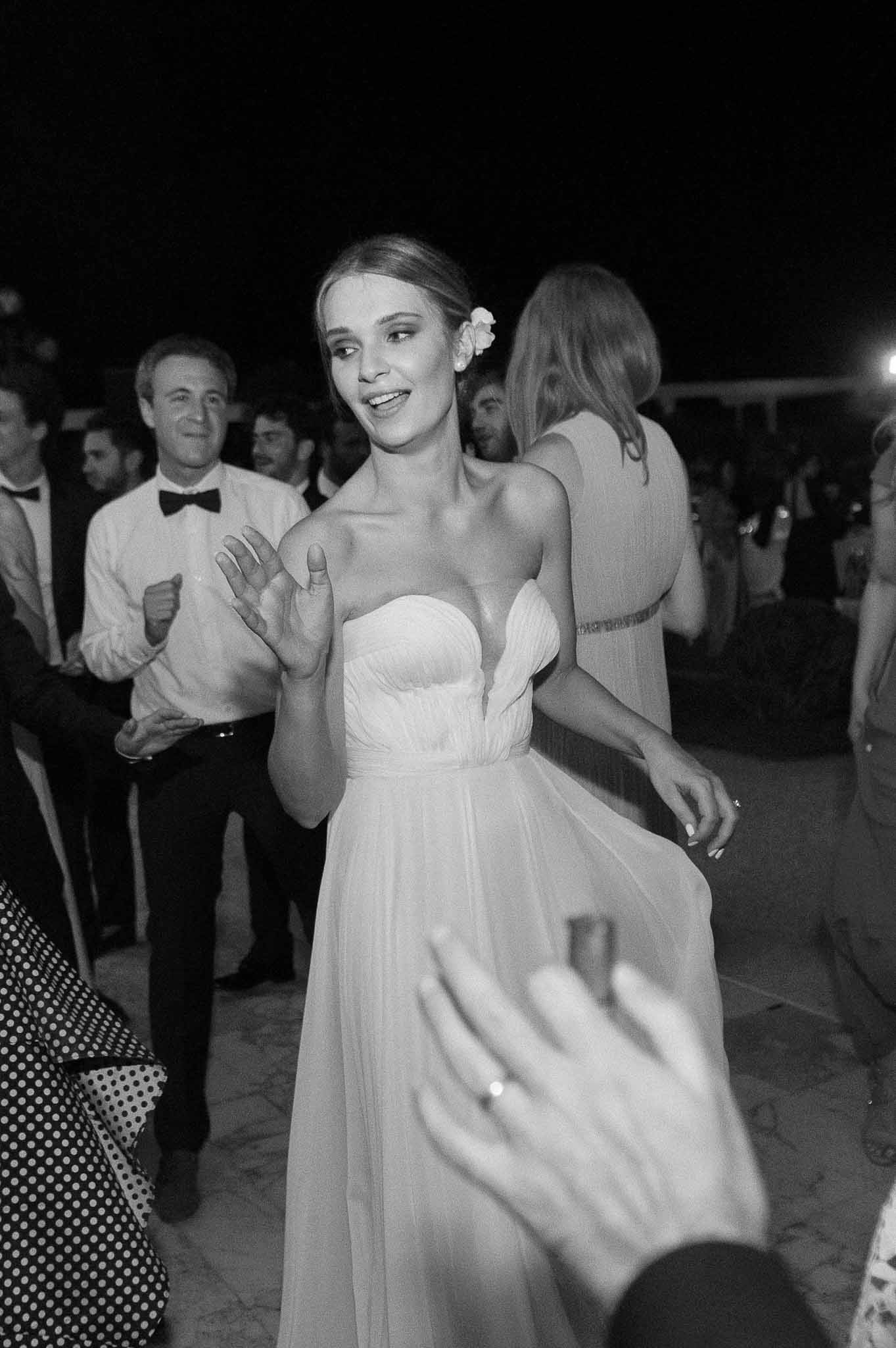 Bride dancing with guests during outdoor reception celebration