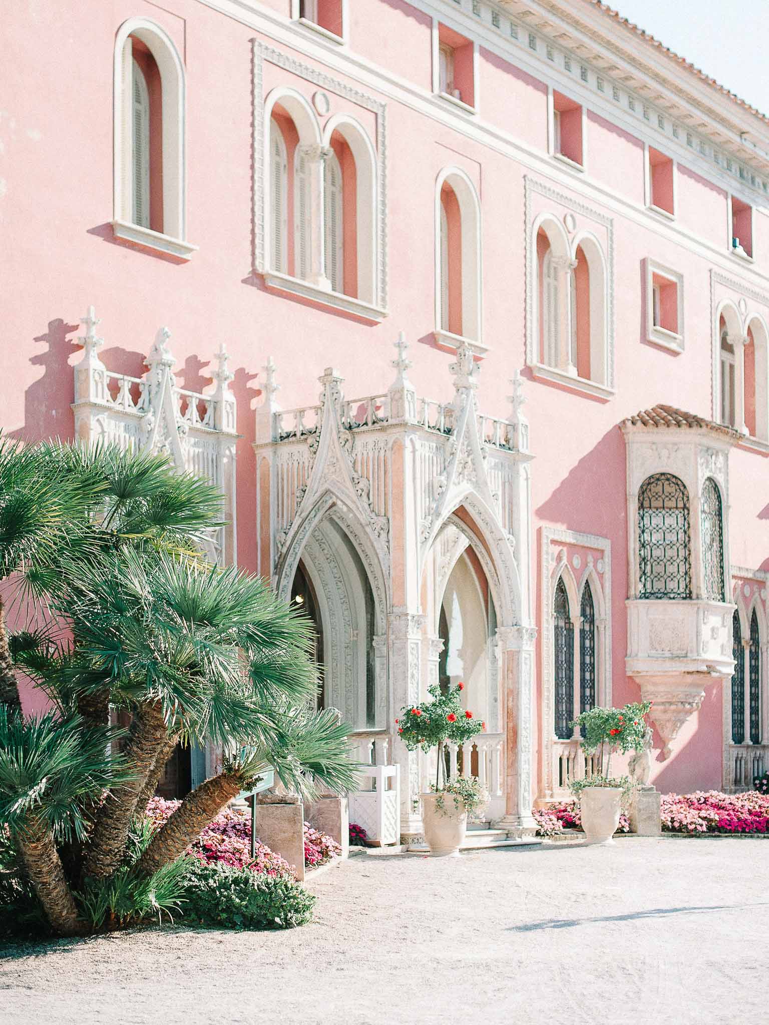 Pink Gothic palazzo wedding venue with ornate archways and flowering courtyard garden