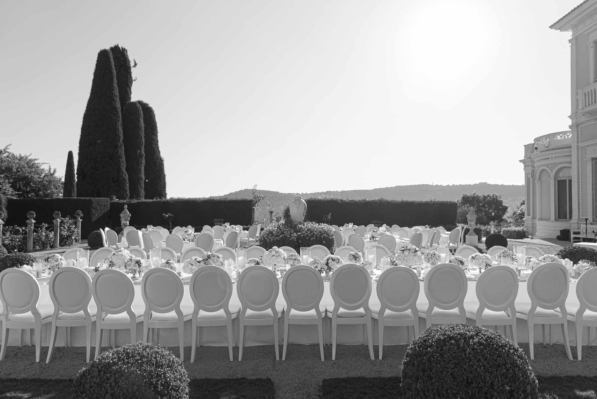 Outdoor reception setup with long banquet tables at European villa estate