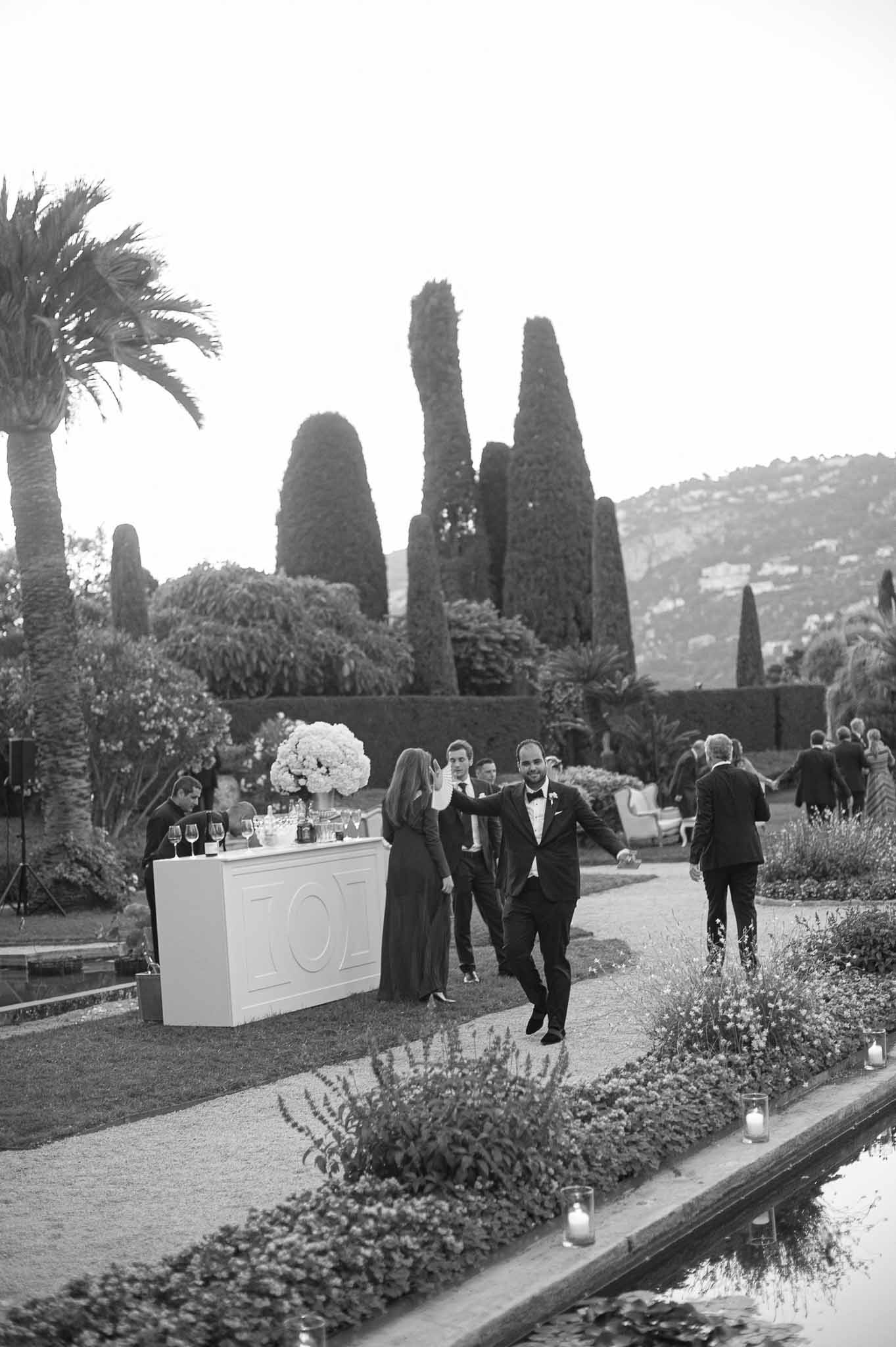 Cocktail hour with guests and bar station in Mediterranean garden with cypress trees and lavender plantings