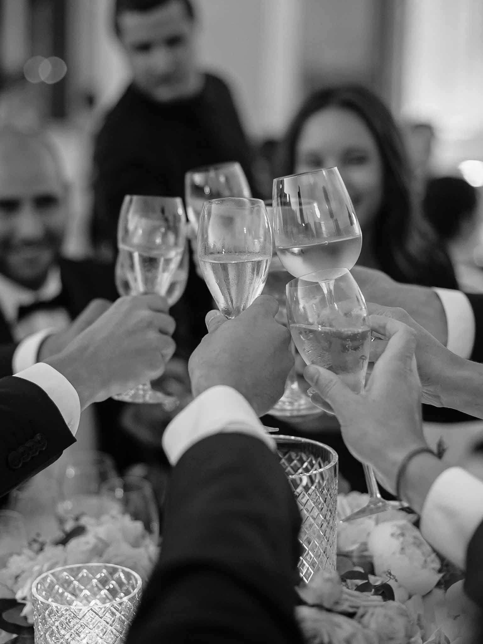 Guests raising glasses in celebratory toast during wedding reception