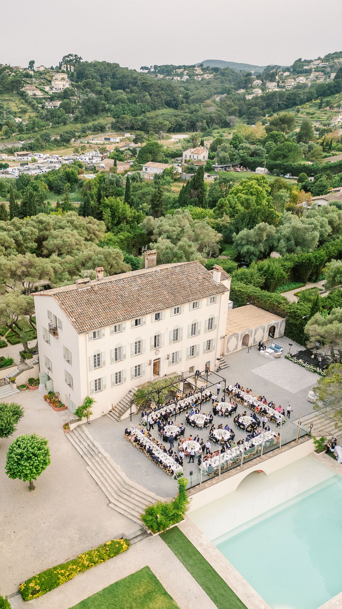 Aerial view of outdoor wedding reception with round tables in courtyard of Provencal bastide villa
