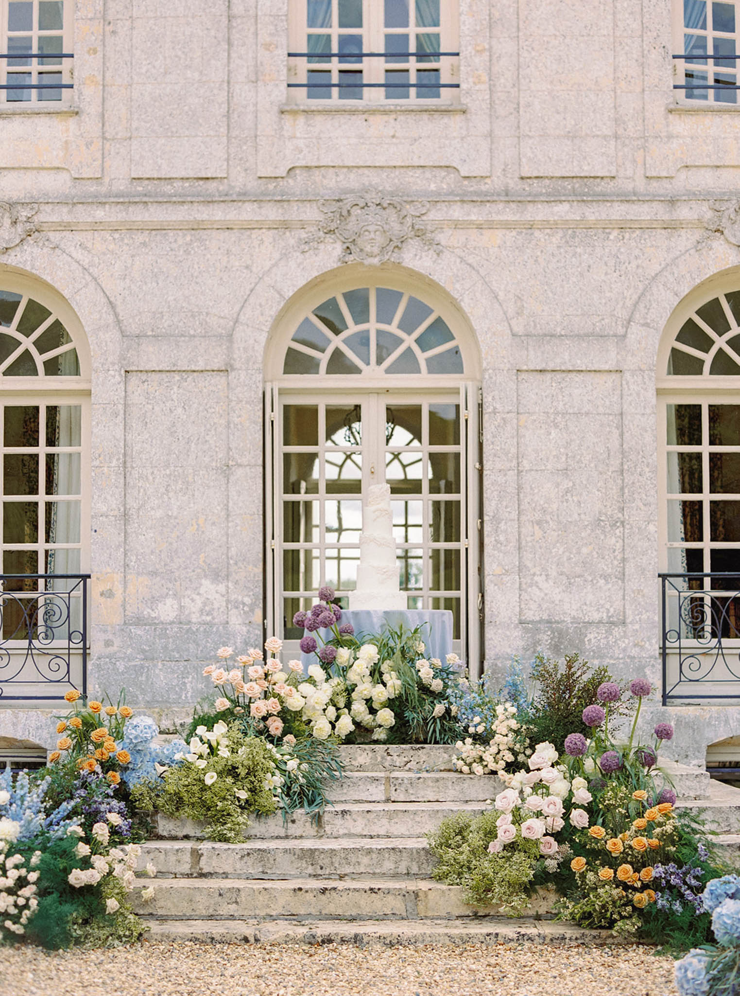 French château stone façade with floral ceremony entrance decoration at historic wedding venue