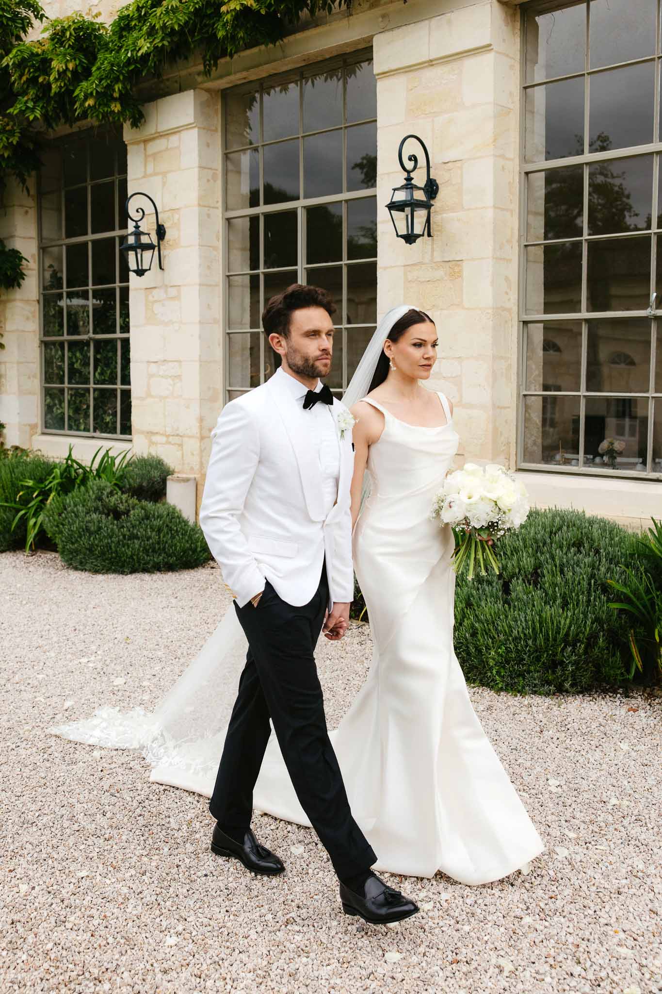 Bride and groom portrait in classical stone courtyard with formal architecture