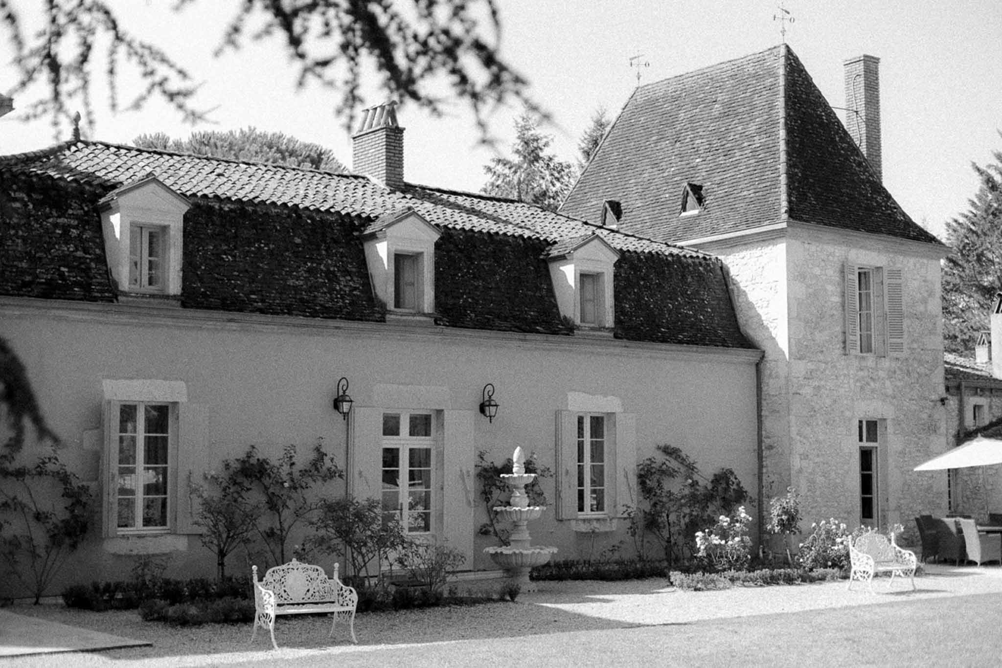 French château wedding venue exterior with fountain and courtyard benches