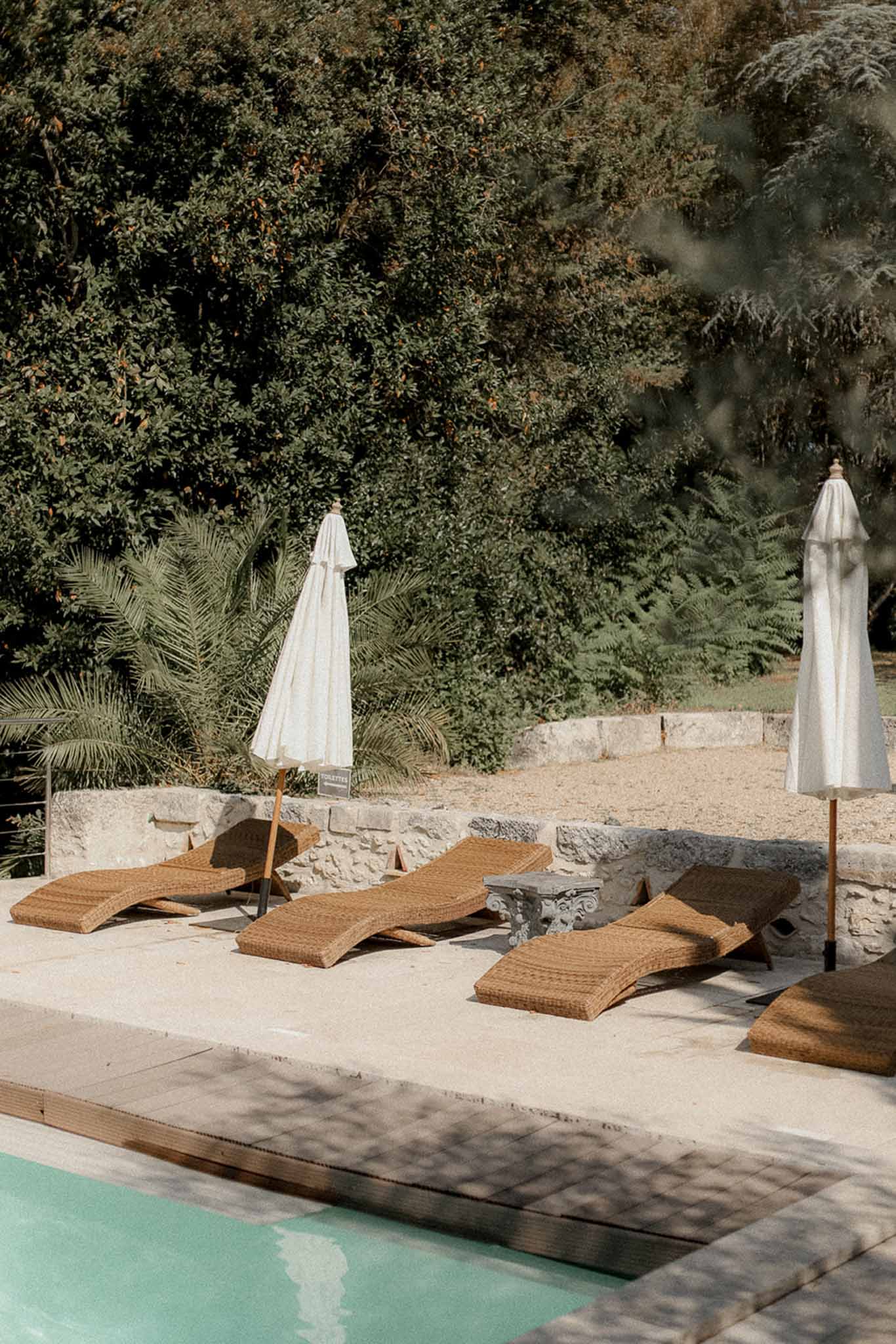 Poolside lounge area with rattan furniture and parasols at Mediterranean wedding venue