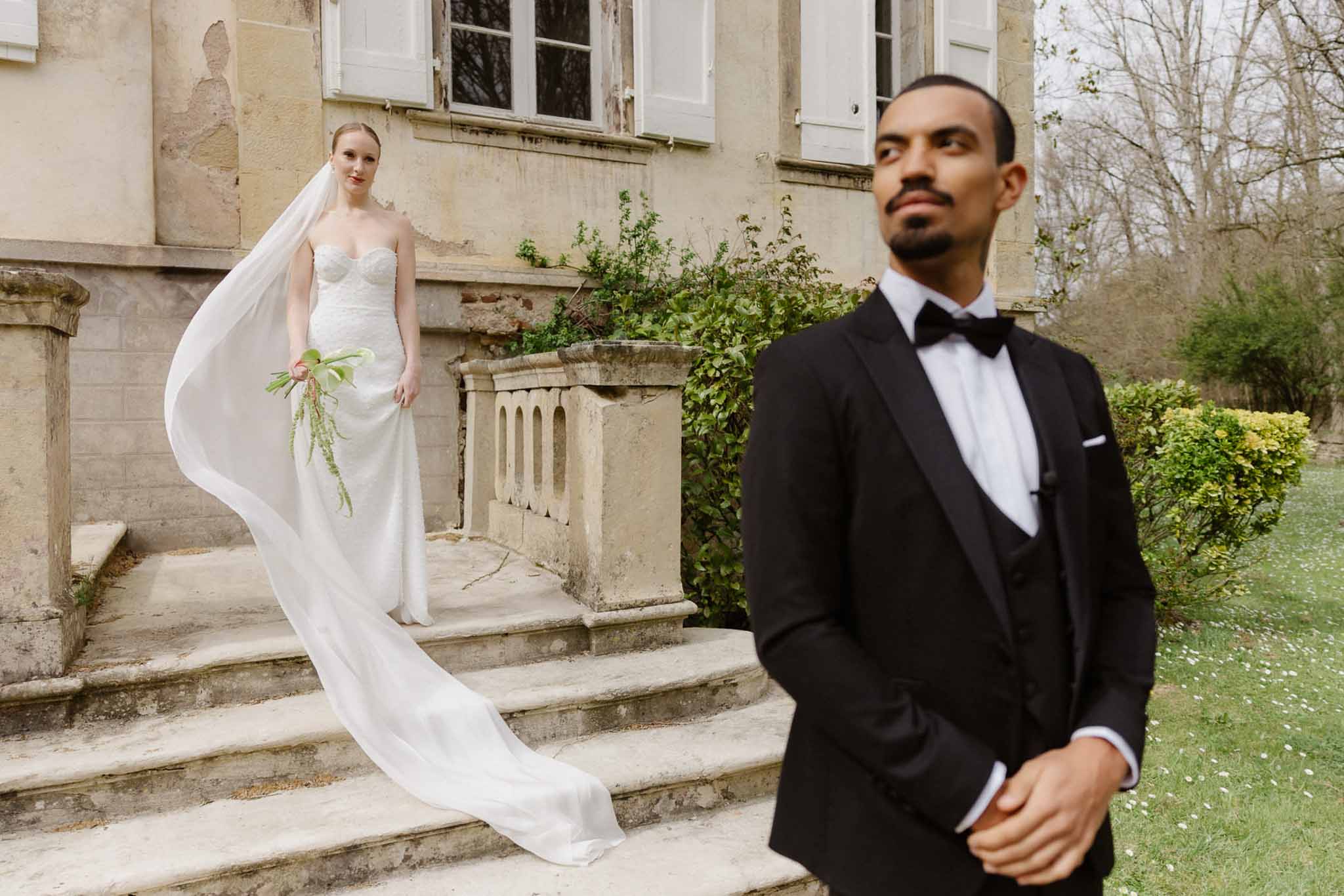 Bride and groom portrait session in historic stone château courtyard with ivy-covered walls