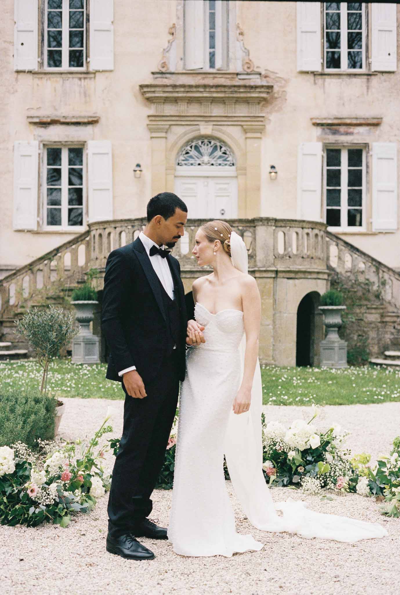 Bride and groom portrait in classical château courtyard with double staircase and architectural details