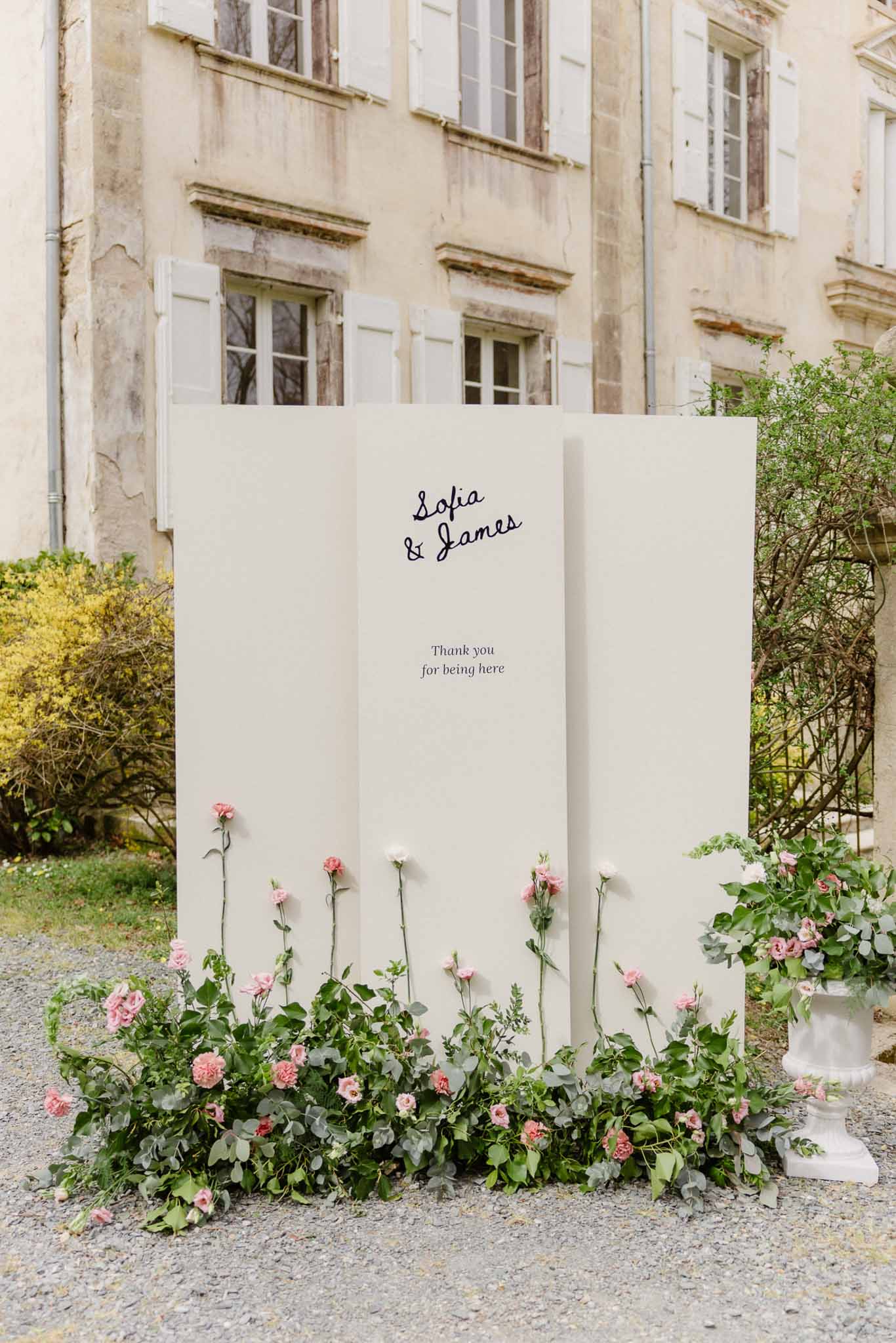 Welcome sign with pink flowers at French château wedding venue