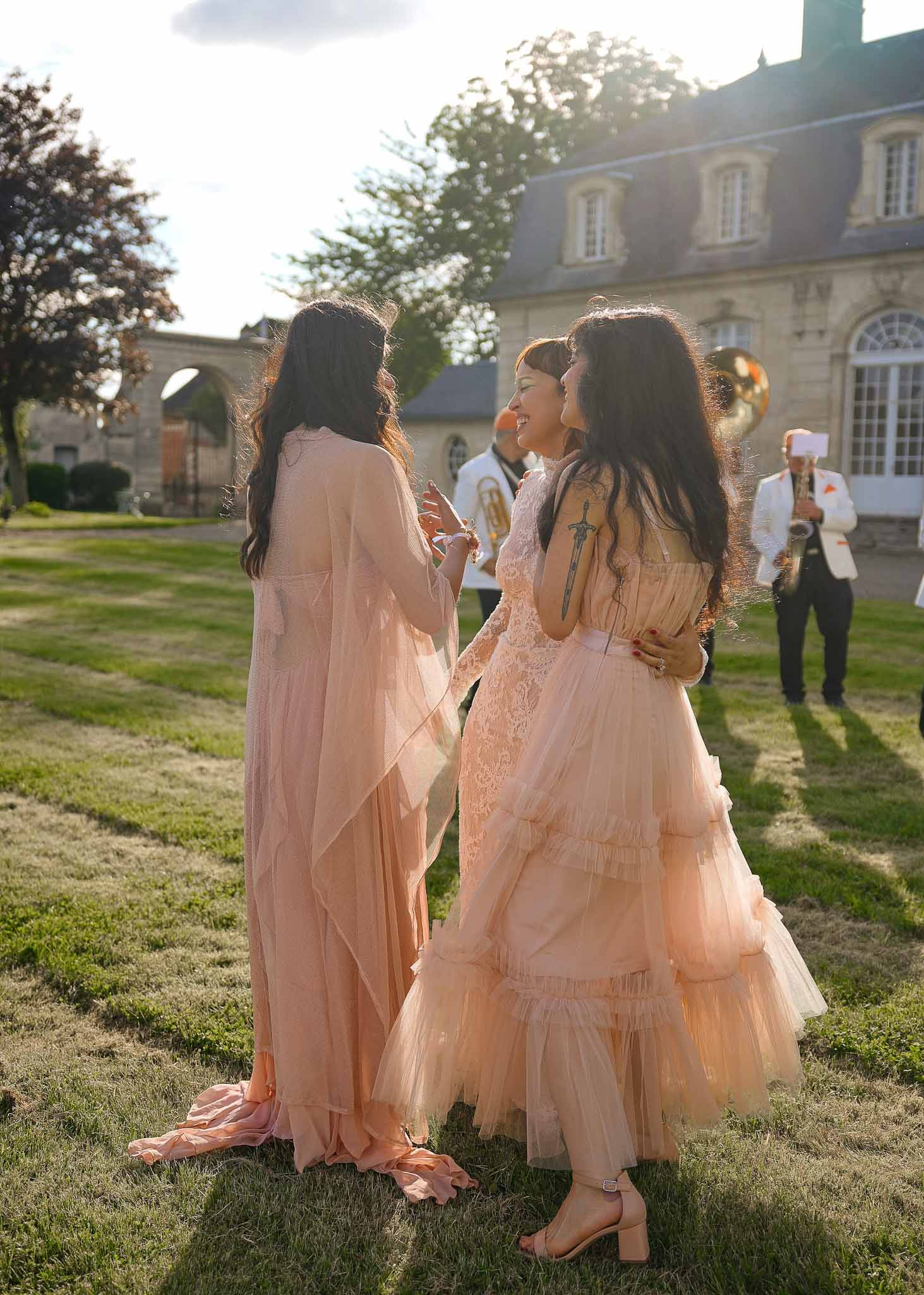Bride and bridesmaids gathering during reception in courtyard of classical stone estate