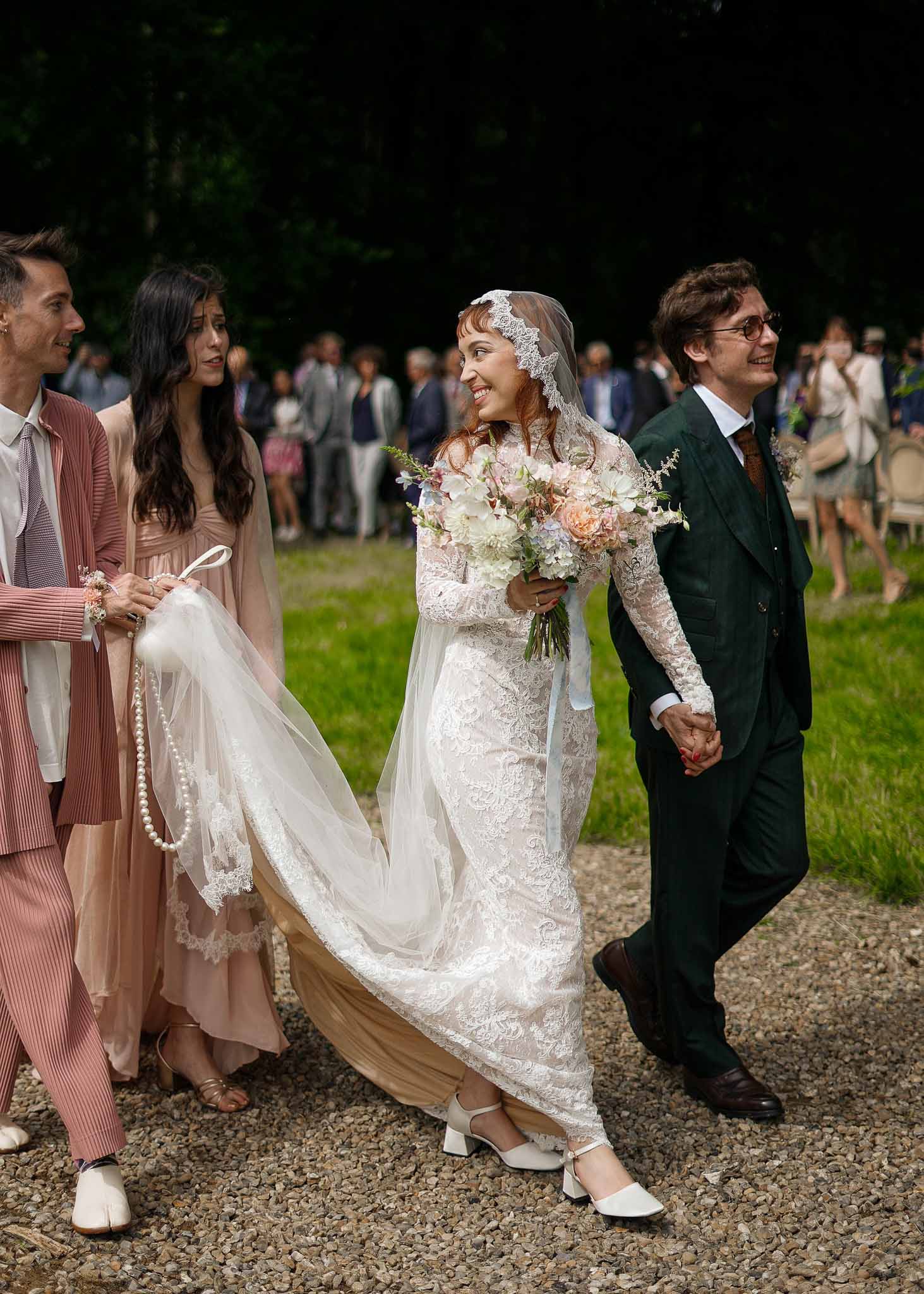 Newlyweds walking together with family after ceremony at garden estate venue