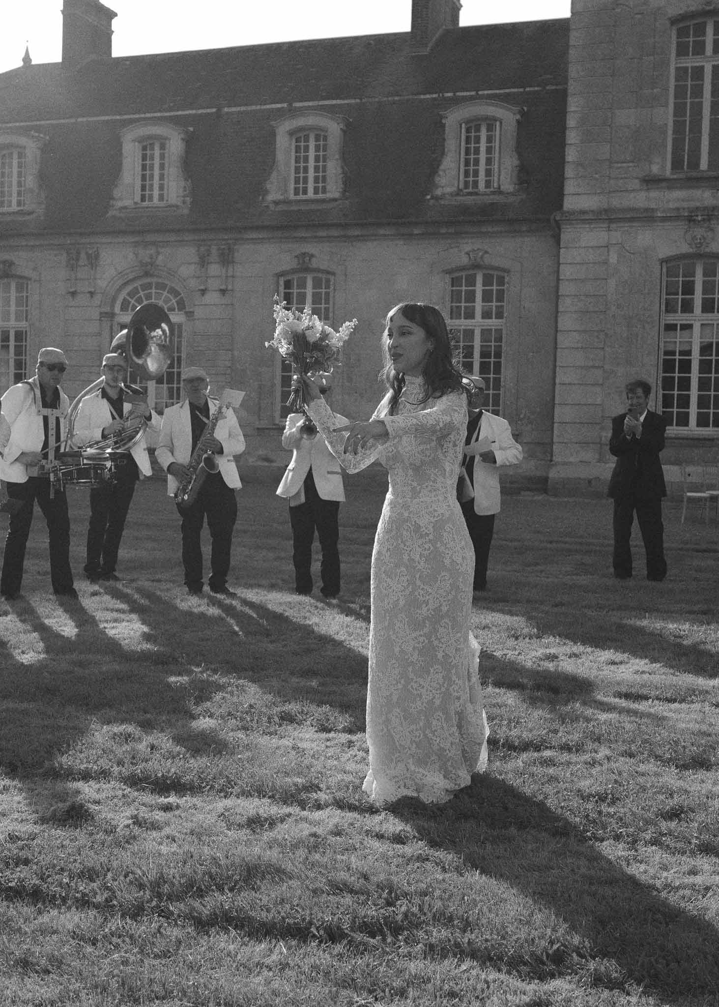 Bride with brass band in courtyard at historic stone manor house wedding reception
