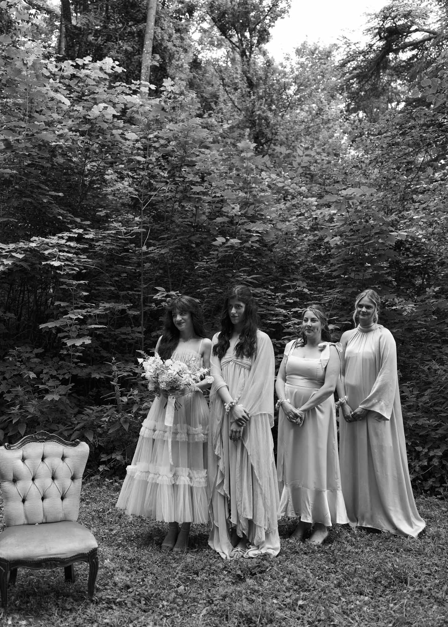 Black and white bridal party portrait with bride and bridesmaids in woodland setting