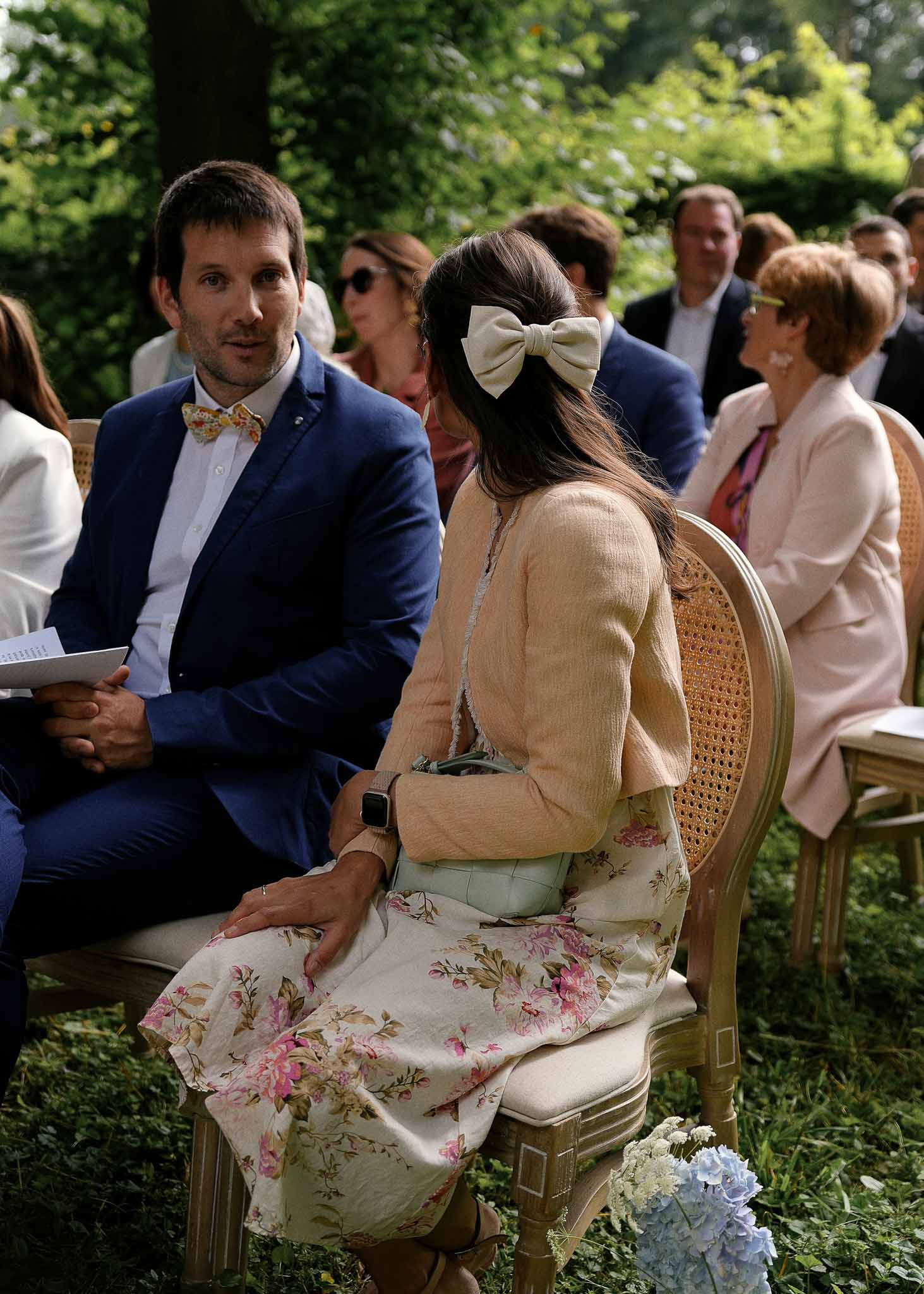 Wedding guests seated during outdoor garden ceremony with hydrangea arrangements